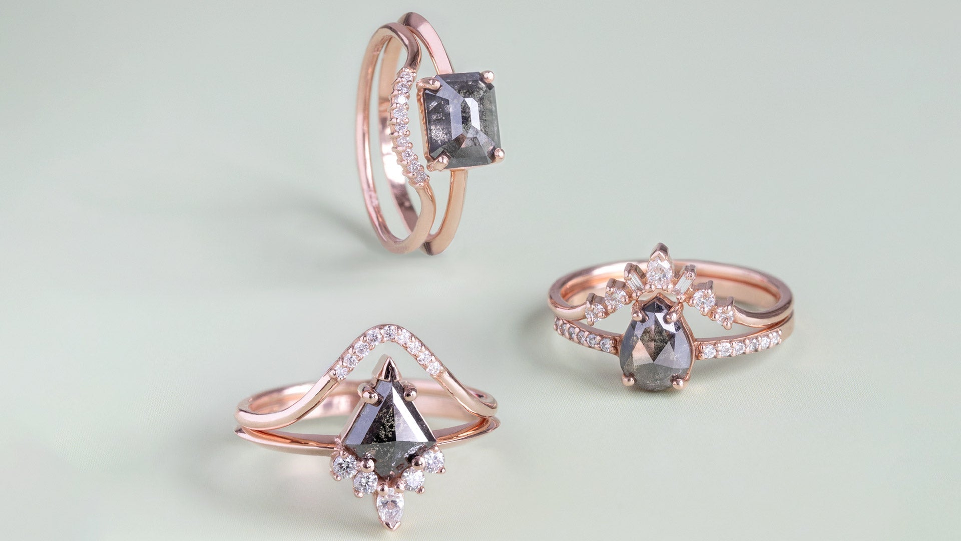 three black diamond engagement rings in 14K rose gold featuring different engagement ring band styles on sage green background