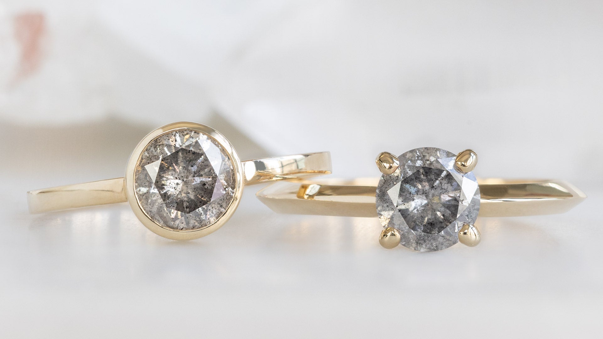 two yellow gold round salt and pepper diamond engagement rings with a prong and bezel setting