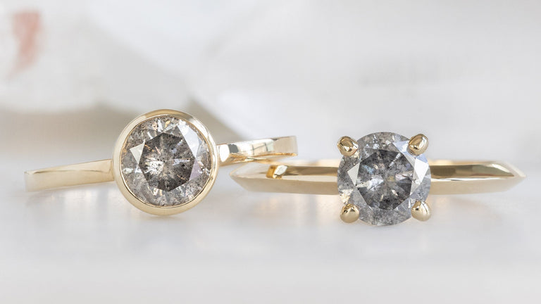 two yellow gold round salt and pepper diamond engagement rings with a prong and bezel setting