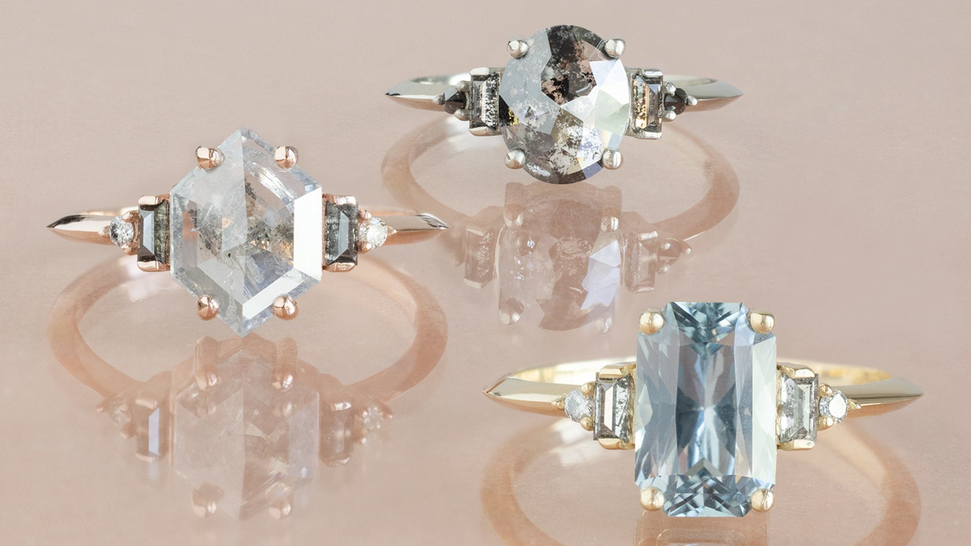 Diamond and Sapphire Gemstone Engagement Rings on Peach Colored Background