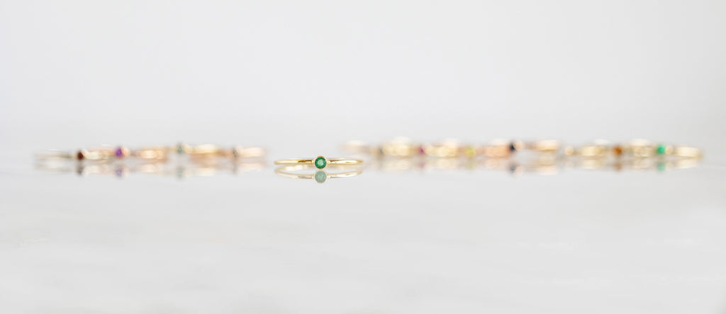 Emerald Birthstone Stacking Ring with other Birthstone Stacking Rings out of focus