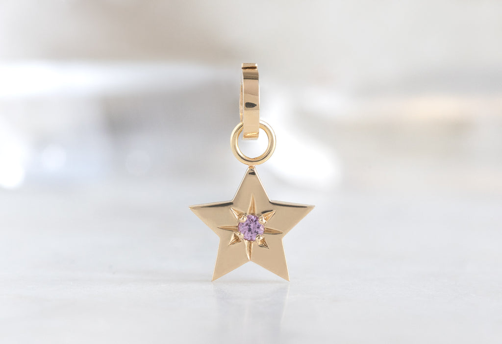 10k Yellow Gold Star Charm on White Marble Tile