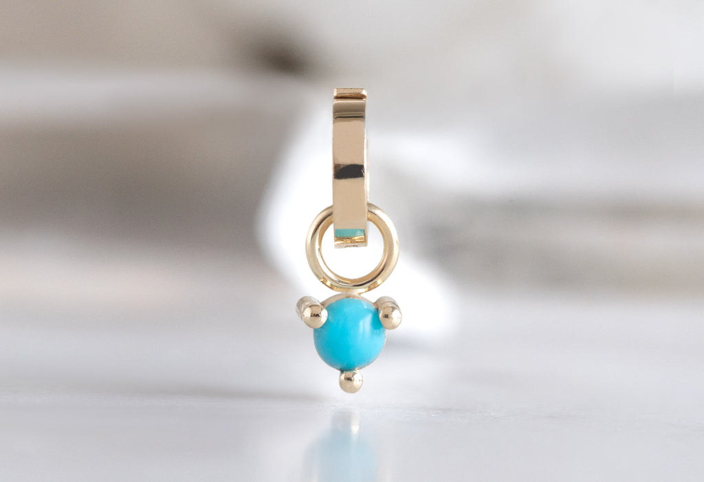 10k Yellow Gold Turquoise Birthstone Charm on White Marble TIle