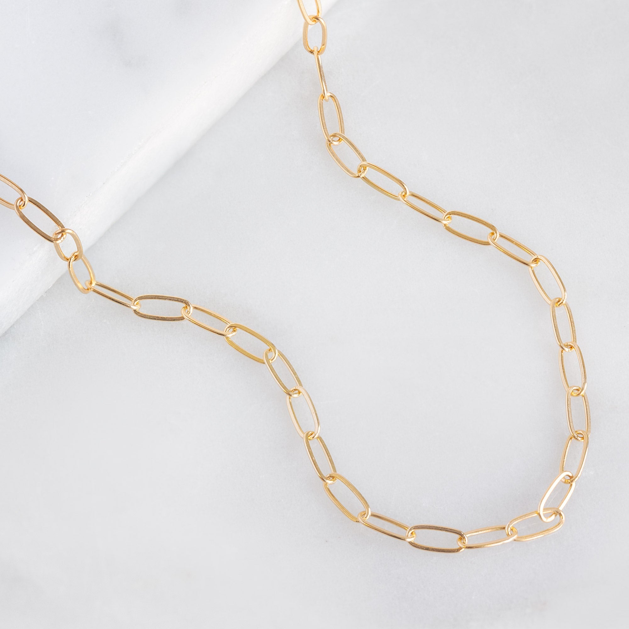 The Drawn Cable Chain Charm Bracelet in 10K Yellow Gold on White Marble