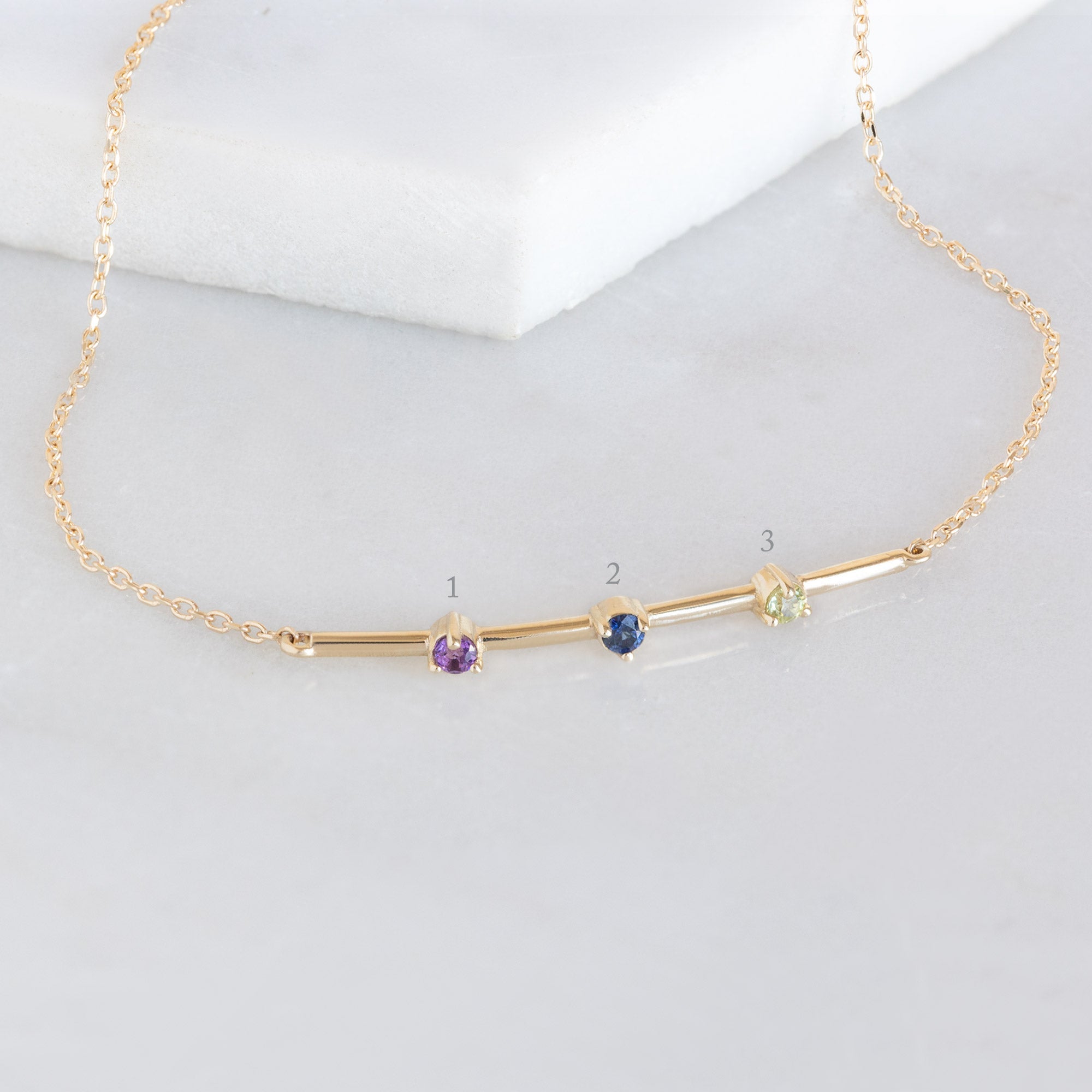 The Custom Multi-Birthstone Bracelet 3 Stone Option on White Marble with Diagram