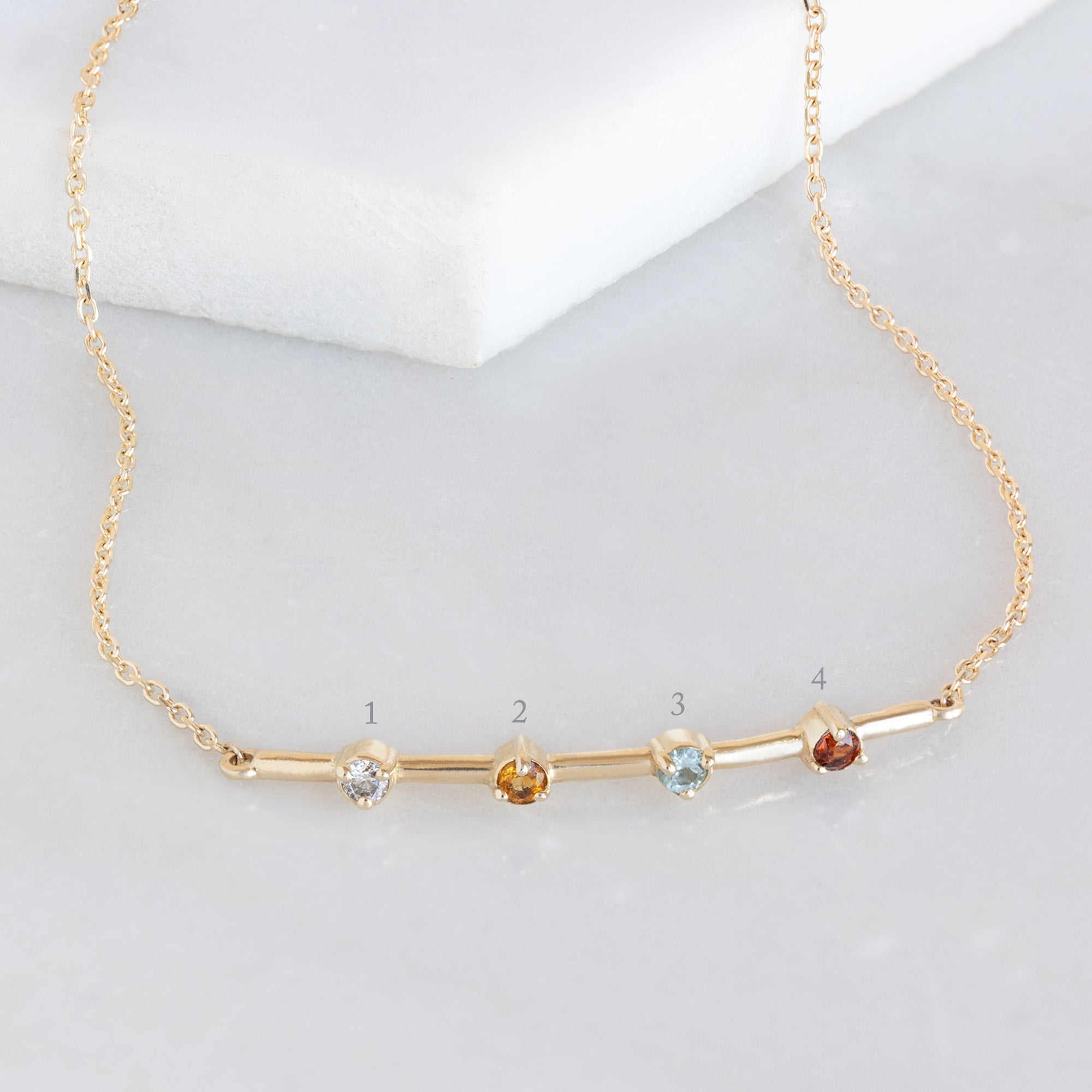 The Custom Multi-Birthstone Bracelet 4 Stone Option on White Marble with Diagram