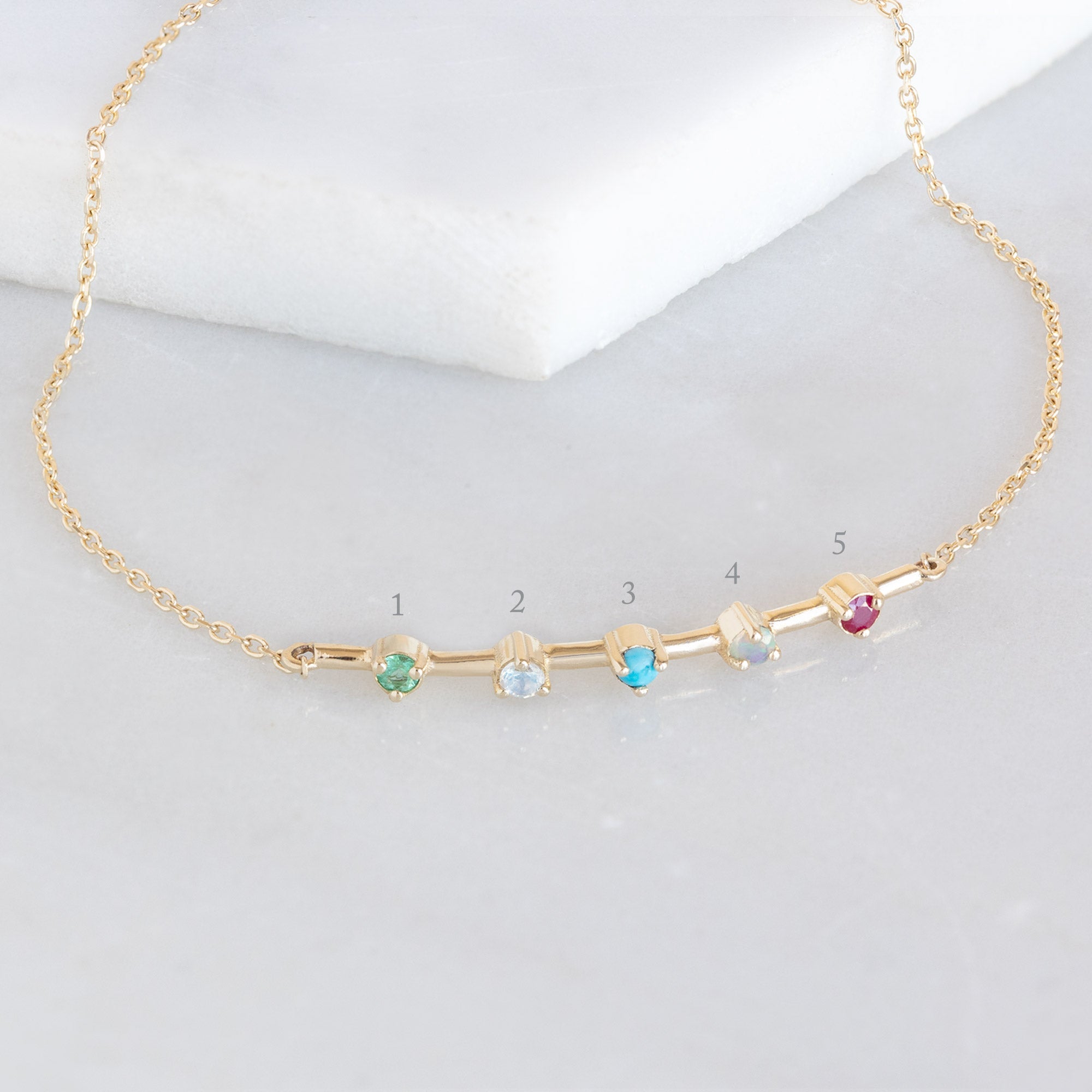 The Custom Multi-Birthstone Bracelet 5 Stone Option on White Marble with Diagram