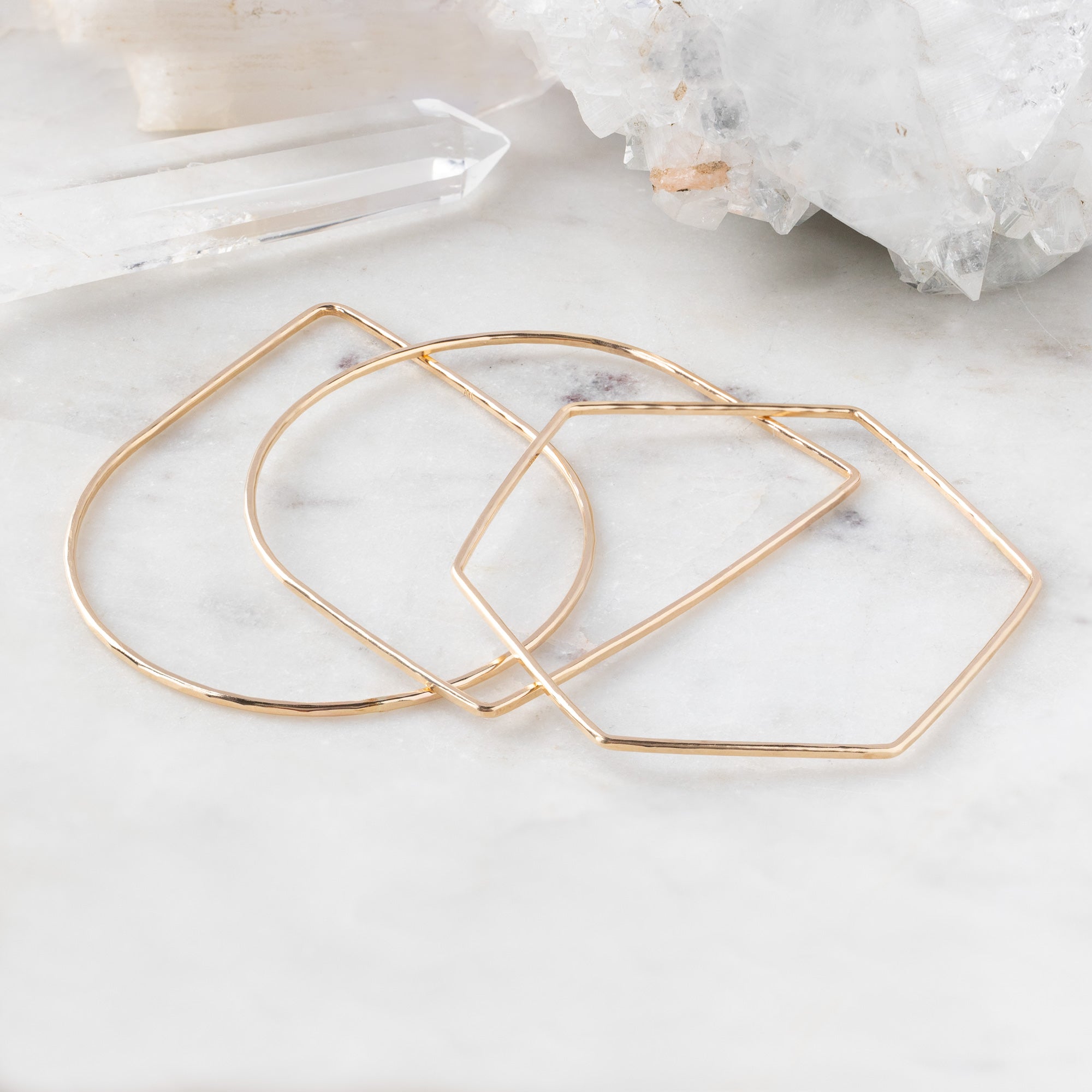 The Geometric Stacking Bangle Set in Yellow Gold Filled on White Marble