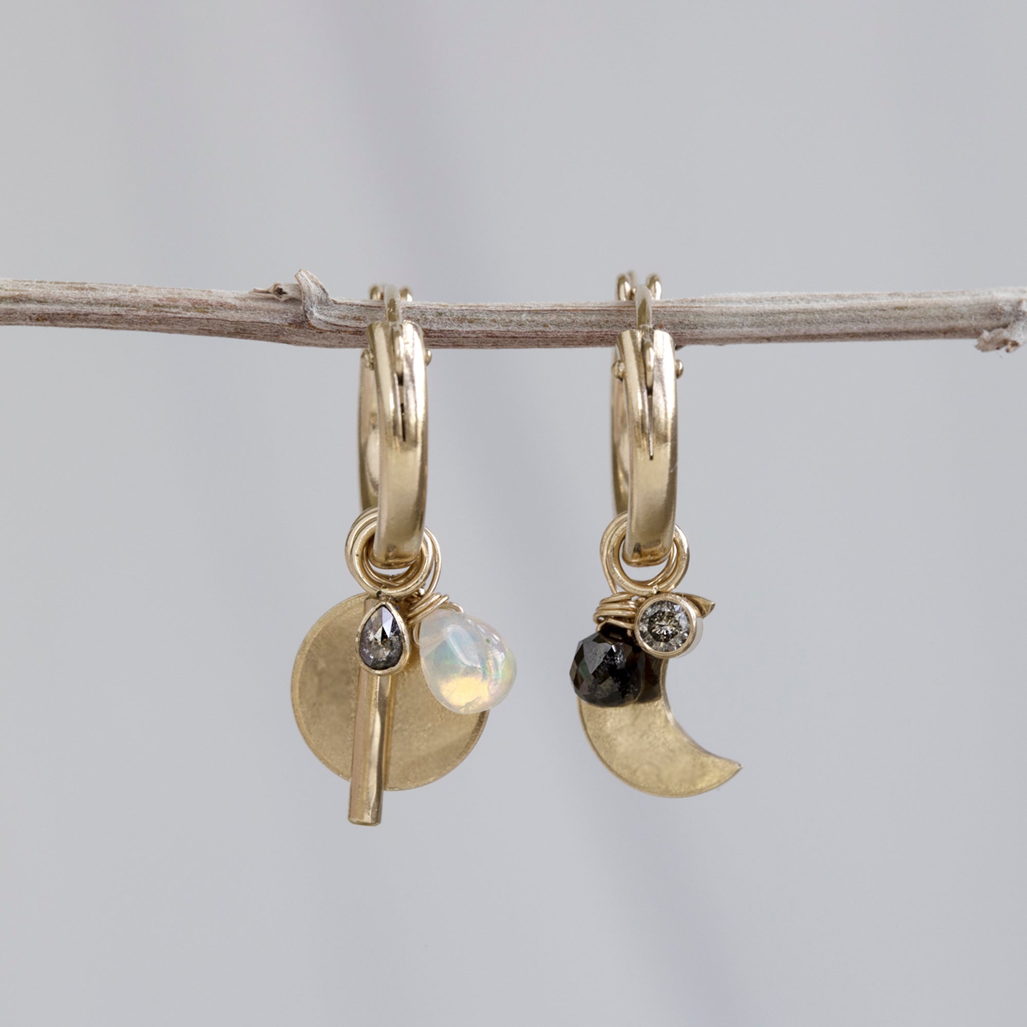 Custom Charm Hoop Earrings | Yellow Gold Filled displayed on holding bar with grey background.