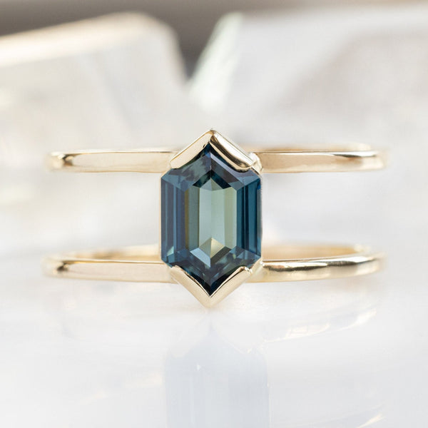 The Poppy Ring with a 1.24ct Hexagon Blue Sapphire in 14K Yellow Gold on White Marble