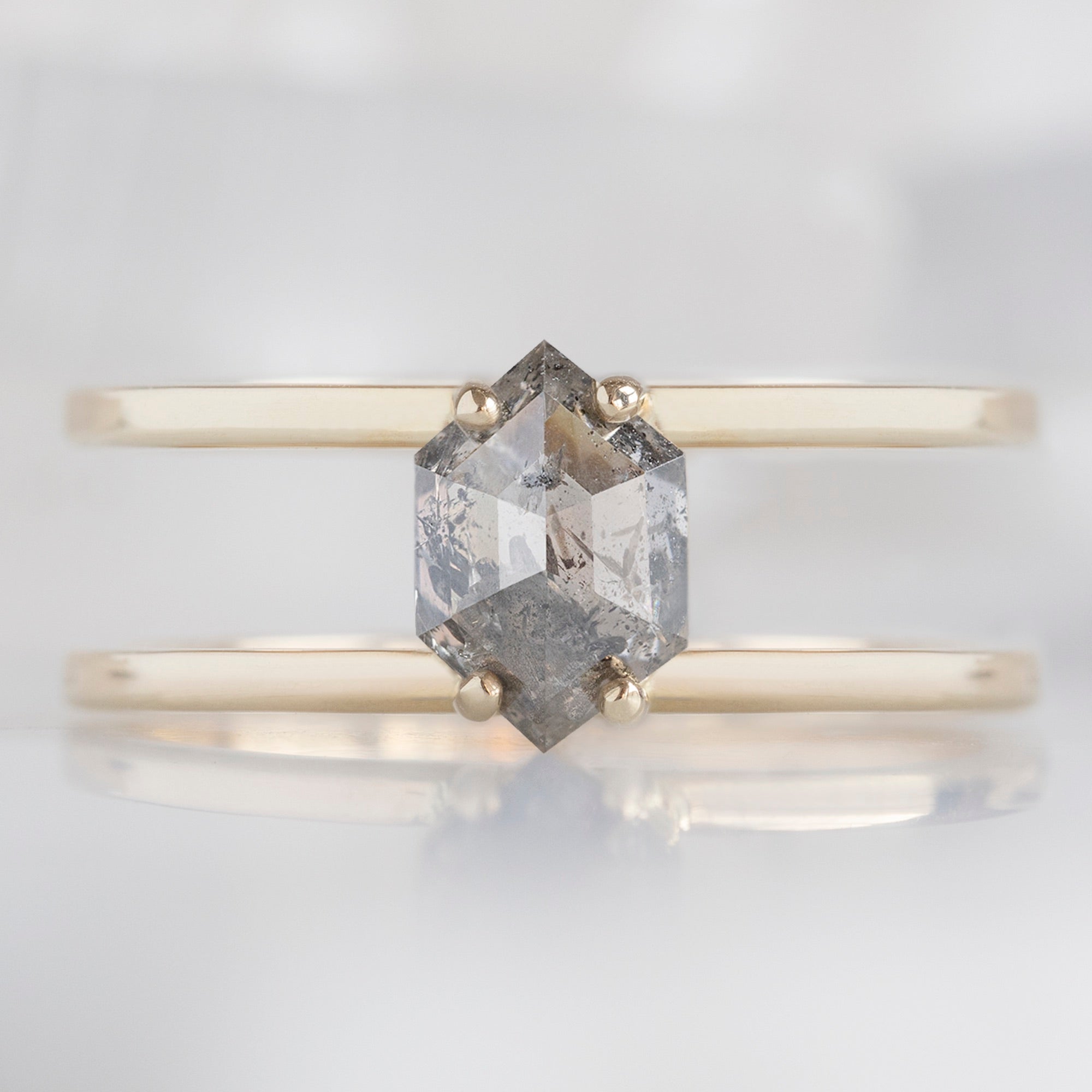The Poppy Ring with a 1.02ct Hexagon Salt and Pepper Diamond in 14K Yellow Gold on White Marble