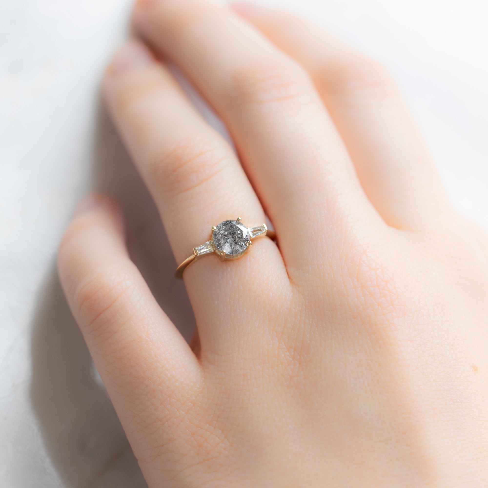 The Ash Ring | 1.22ct Round Salt and Pepper Diamond in 14K Yellow Gold displayed on model's left hand ring finger.