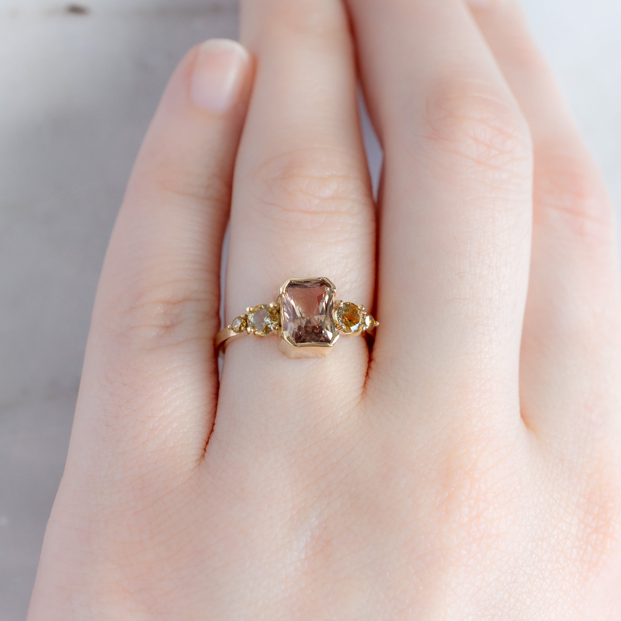 The Watercolor Ring in 2.04ct Emerald Cut Peach Sapphire in 14K Yellow Gold on model