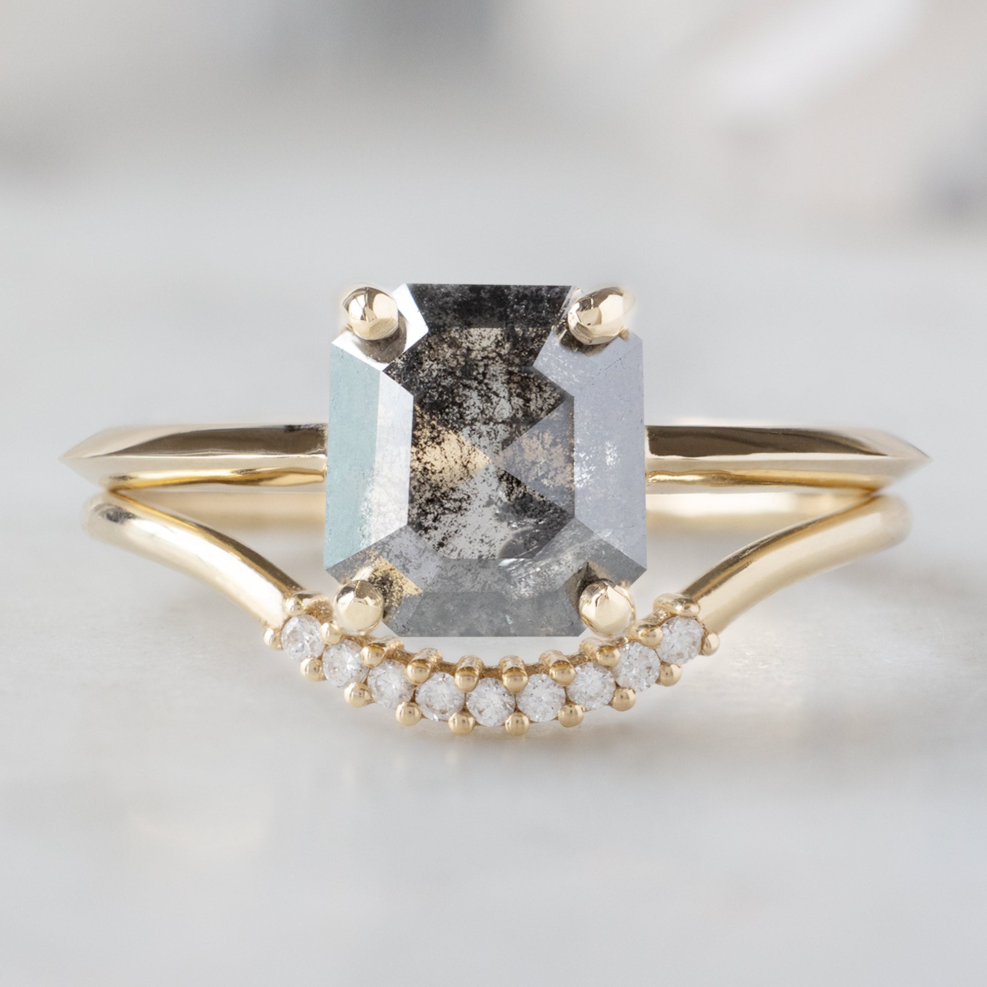 The Bryn Ring with a 1.46ct Emerald Cut Salt and Pepper Diamond in 14K Yellow Gold Stacked with the Pavé White Diamond Arc Stacking Ring