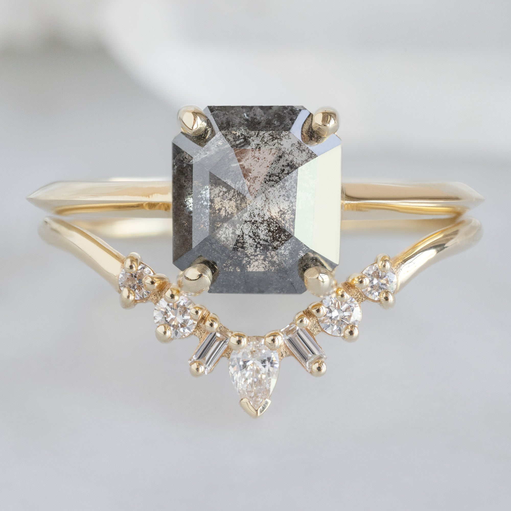 The Bryn Ring with a 1.46ct Emerald Cut Salt and Pepper Diamond in 14K Yellow Gold Stacked with the White Diamond Sunburst Stacking Band