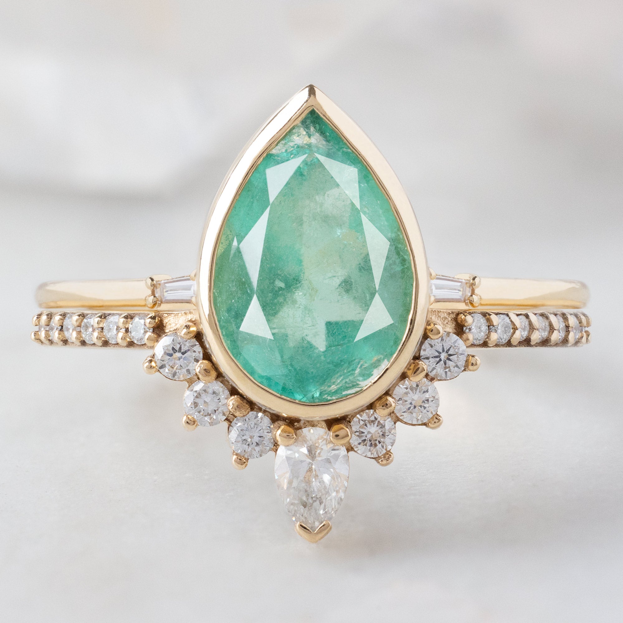 The Aster Ring with a 2.12ct Pear Emerald in 14K Yellow Gold Stacked with the Open Cuff Baguette Stacking Band