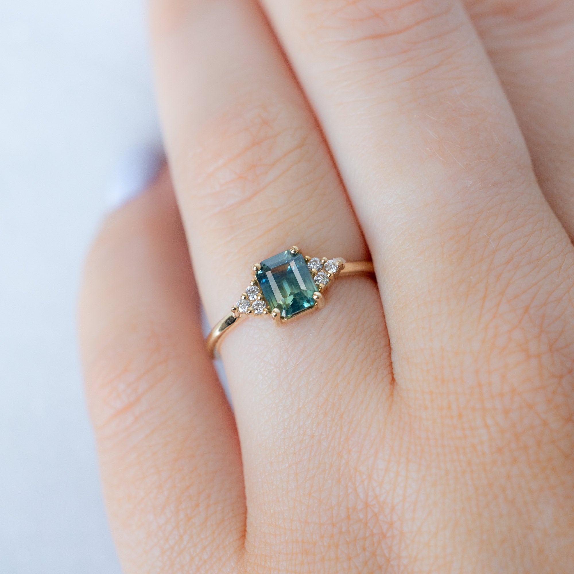 The Ivy Ring with a 1.06ct Emerald Cut Teal Sapphire in 14K Yellow Gold on Model