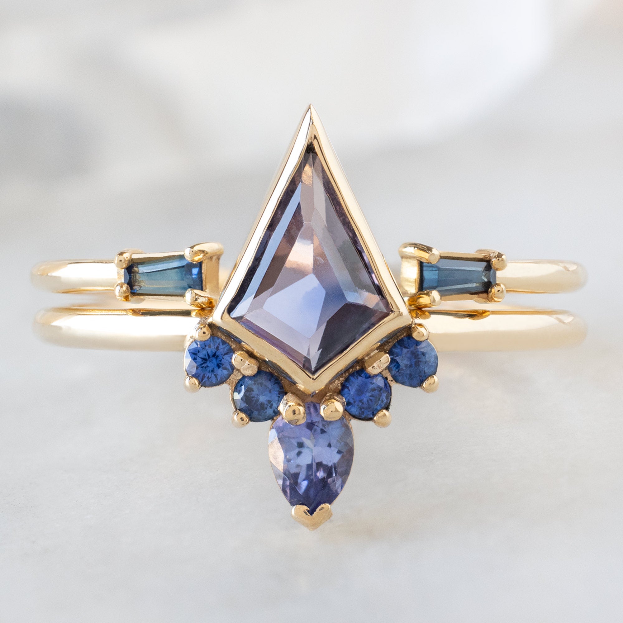 The Watercolor Aster Ring with a 0.83ct Violet Kite Sapphire in 14K Yellow Gold Stacked with the Open Cuff Montana Sapphire Baguette Stacking Band