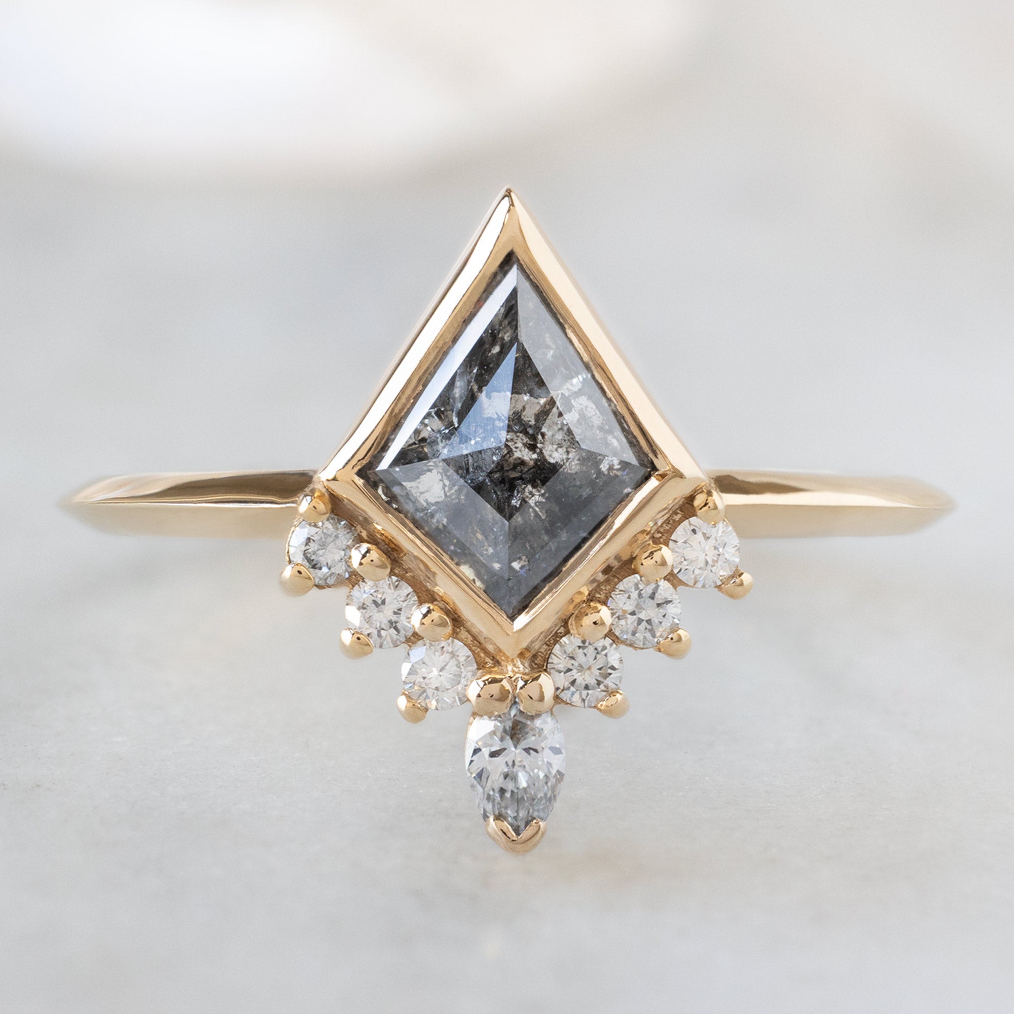 The Aster Ring with a 1.02ct Kite Salt and Pepper Diamond in 14K Yellow Gold on White Marble