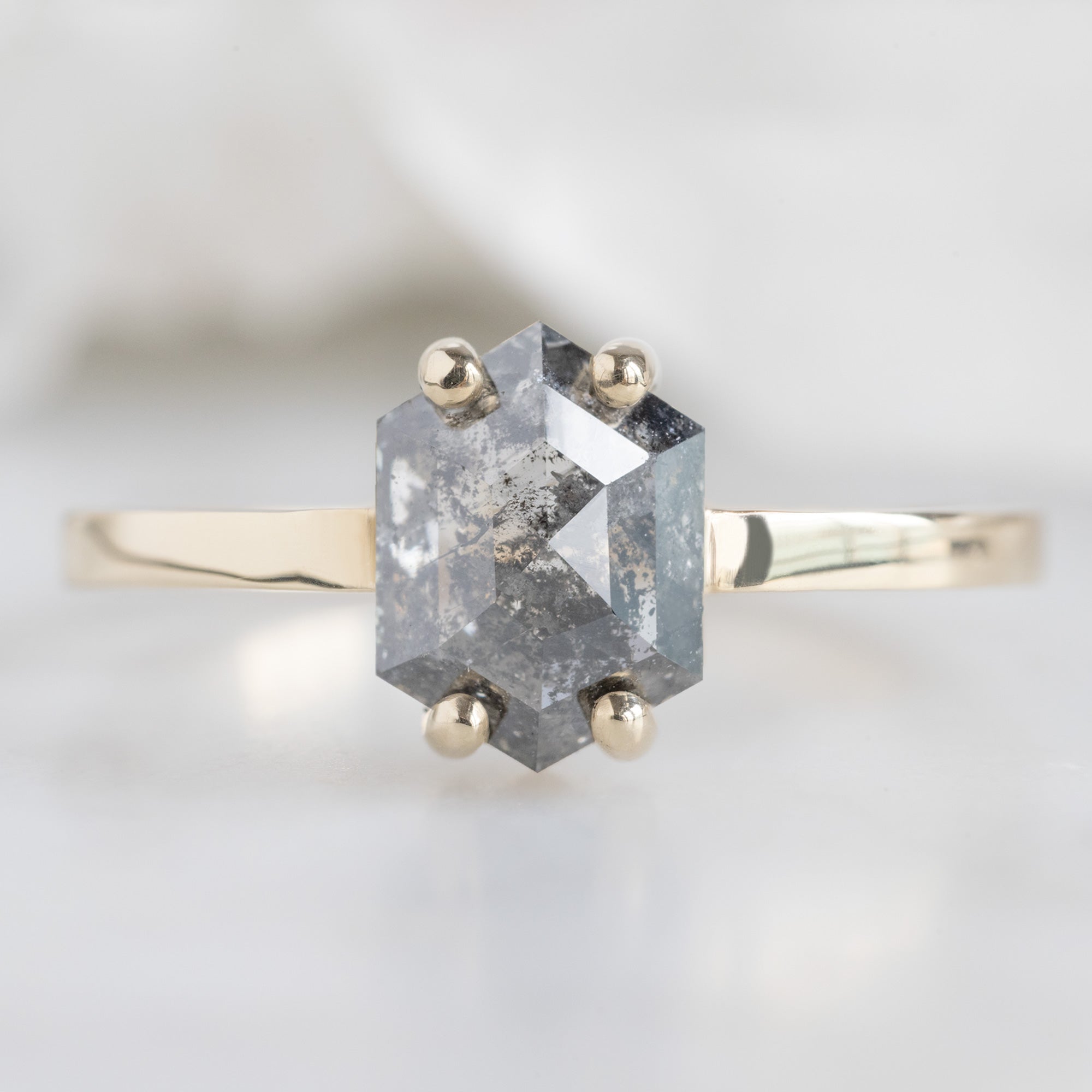 The Bryn Ring with a 1.42ct Hexagon Salt and Pepper Diamond in 14K Yellow Gold on White Marble