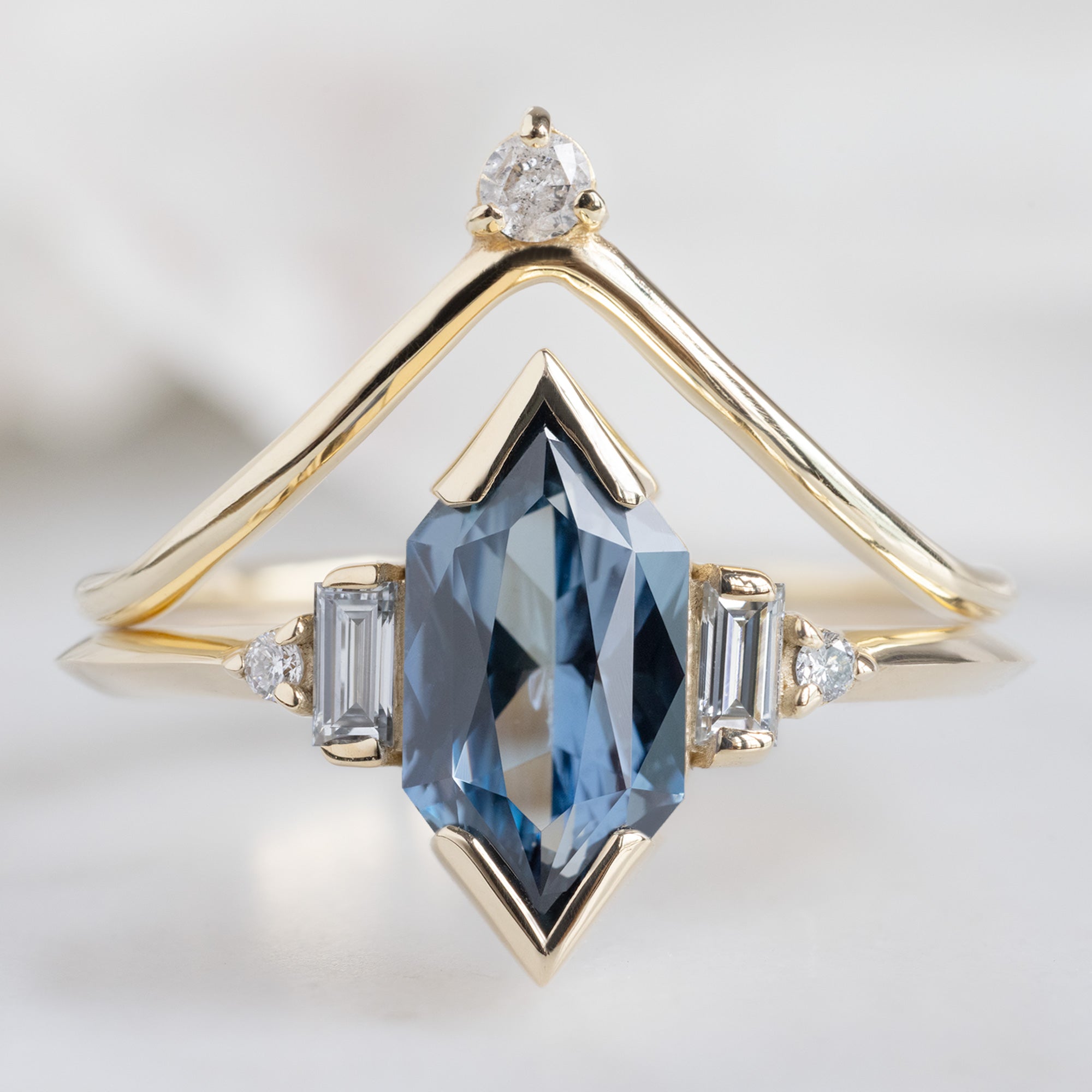 The Primrose Ring with a 1.54ct Blue Sapphire Hexagon in 14K Yellow Gold Stacked with the White Diamond Crown Stacking Ring