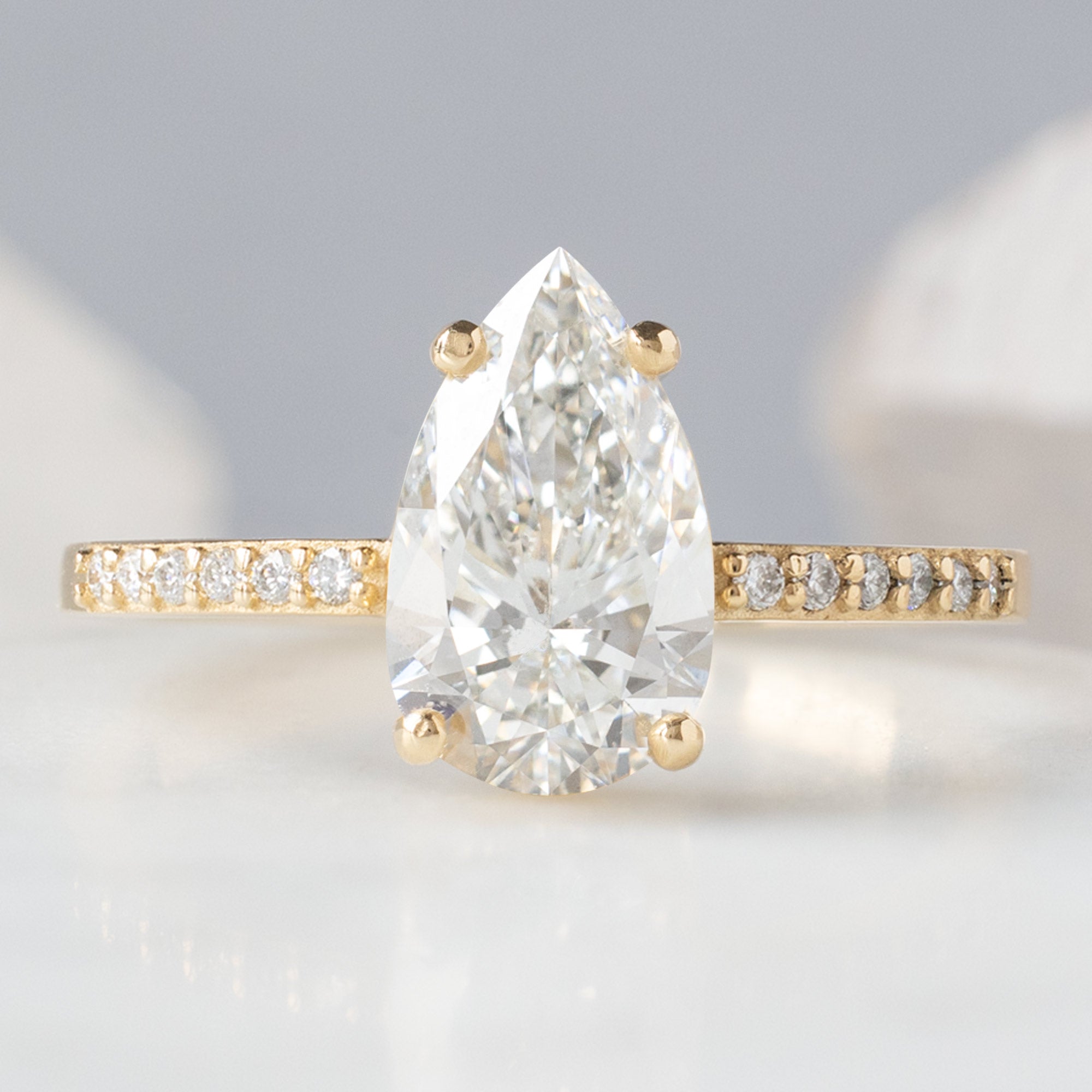 The Willow Ring with a 1.39ct Lab Grown Pear White Diamond in 14K Yellow Gold on White Marble