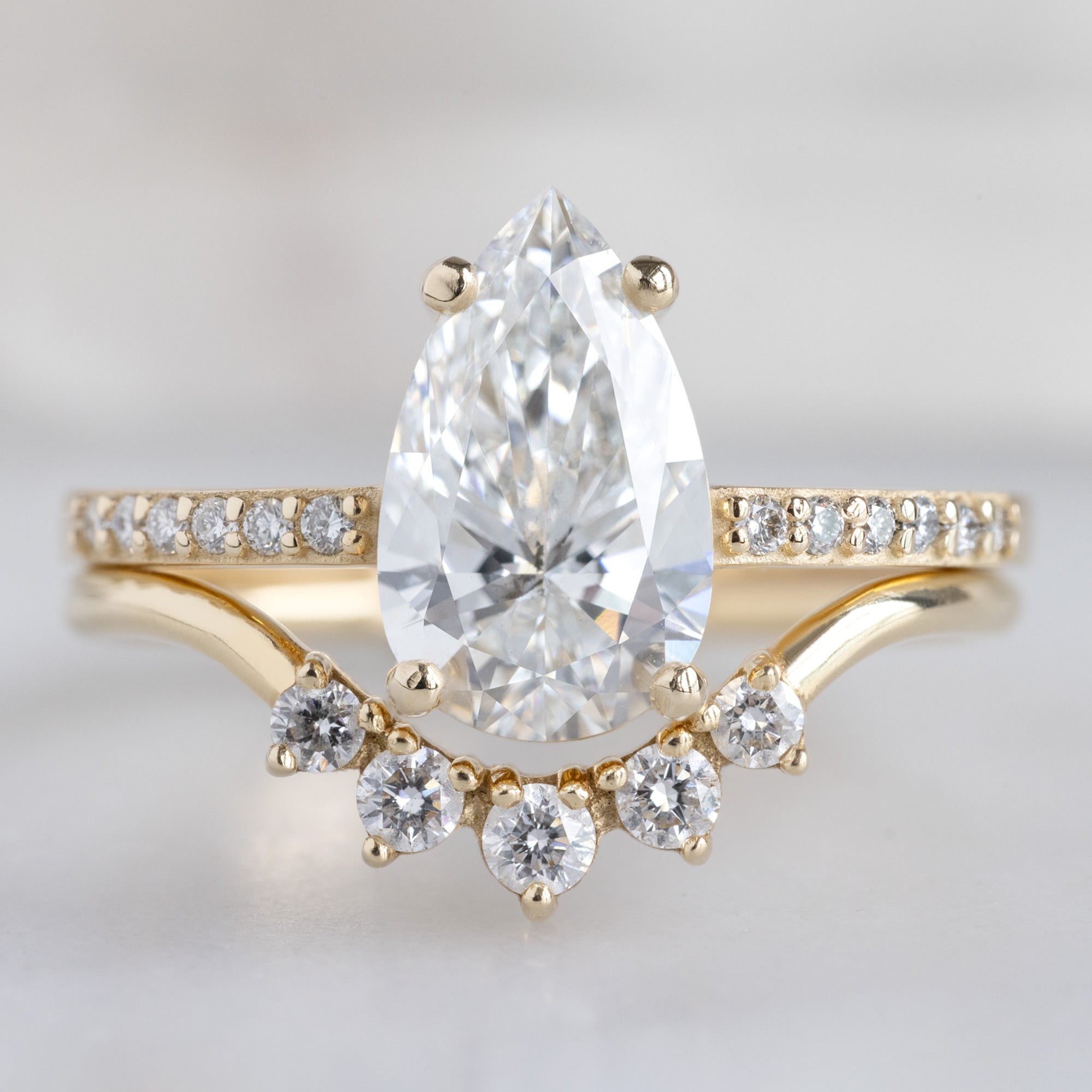 The Willow Ring with a 1.39ct Lab Grown Pear White Diamond in 14K Yellow Gold Stacked with the Round White Diamond Sunburst Stacking Band