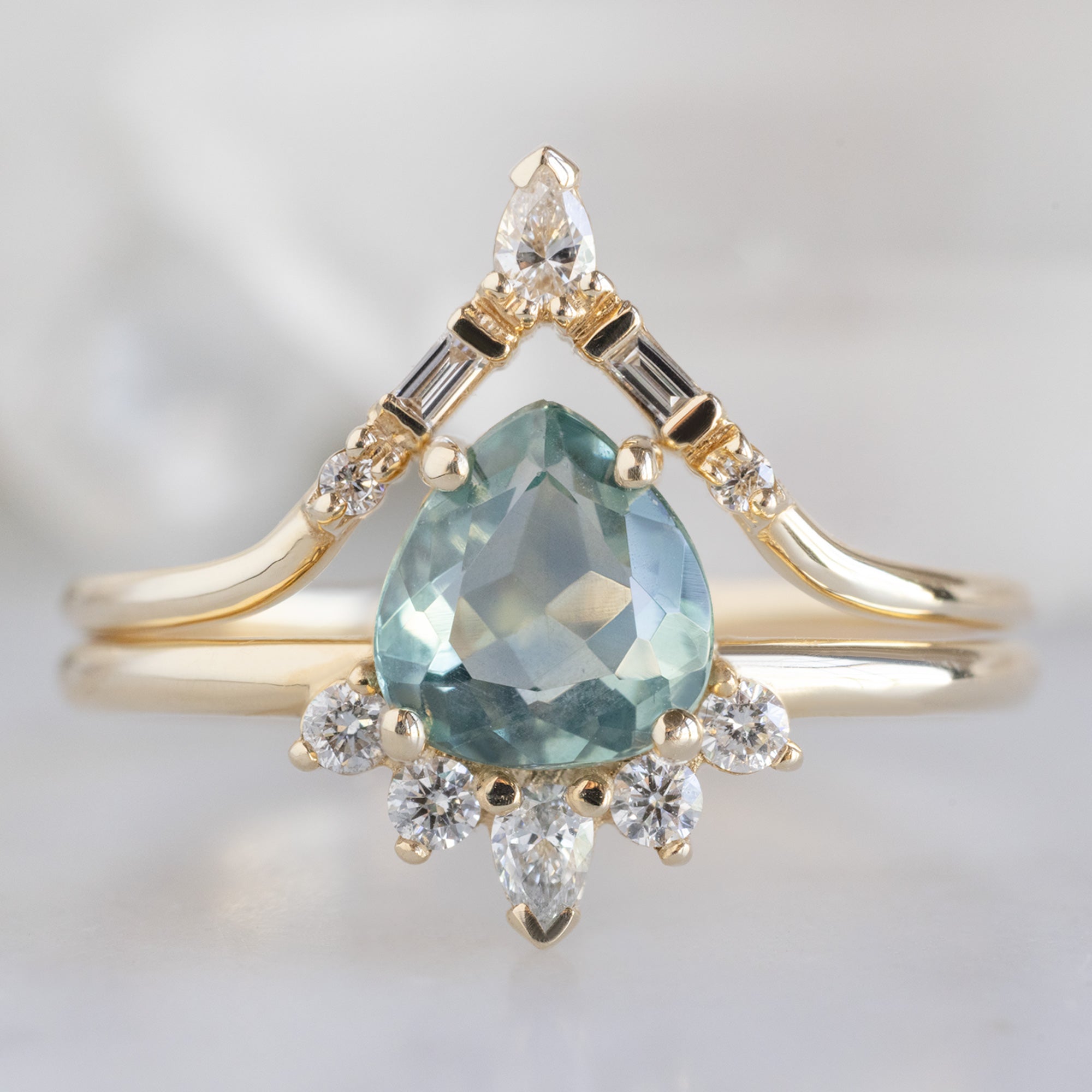 The Aster Ring with a Pear Blue Sapphire in 14k Yellow Gold stacked with the White Diamond Tiara Stacking Band