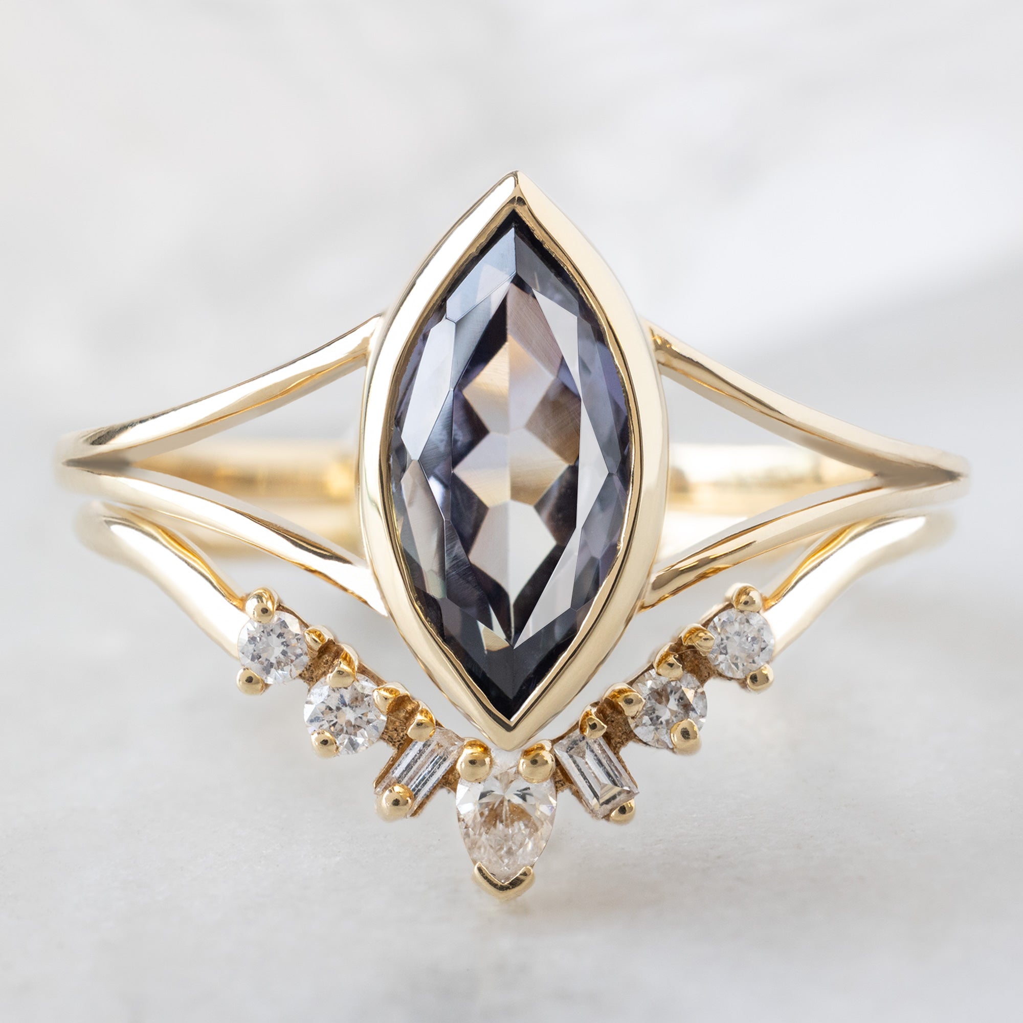 The Magnolia Ring with a 1.63ct Marquise Tanzanite in 14K Yellow Gold Stacked with the Geometric Sunburst Stacking Band