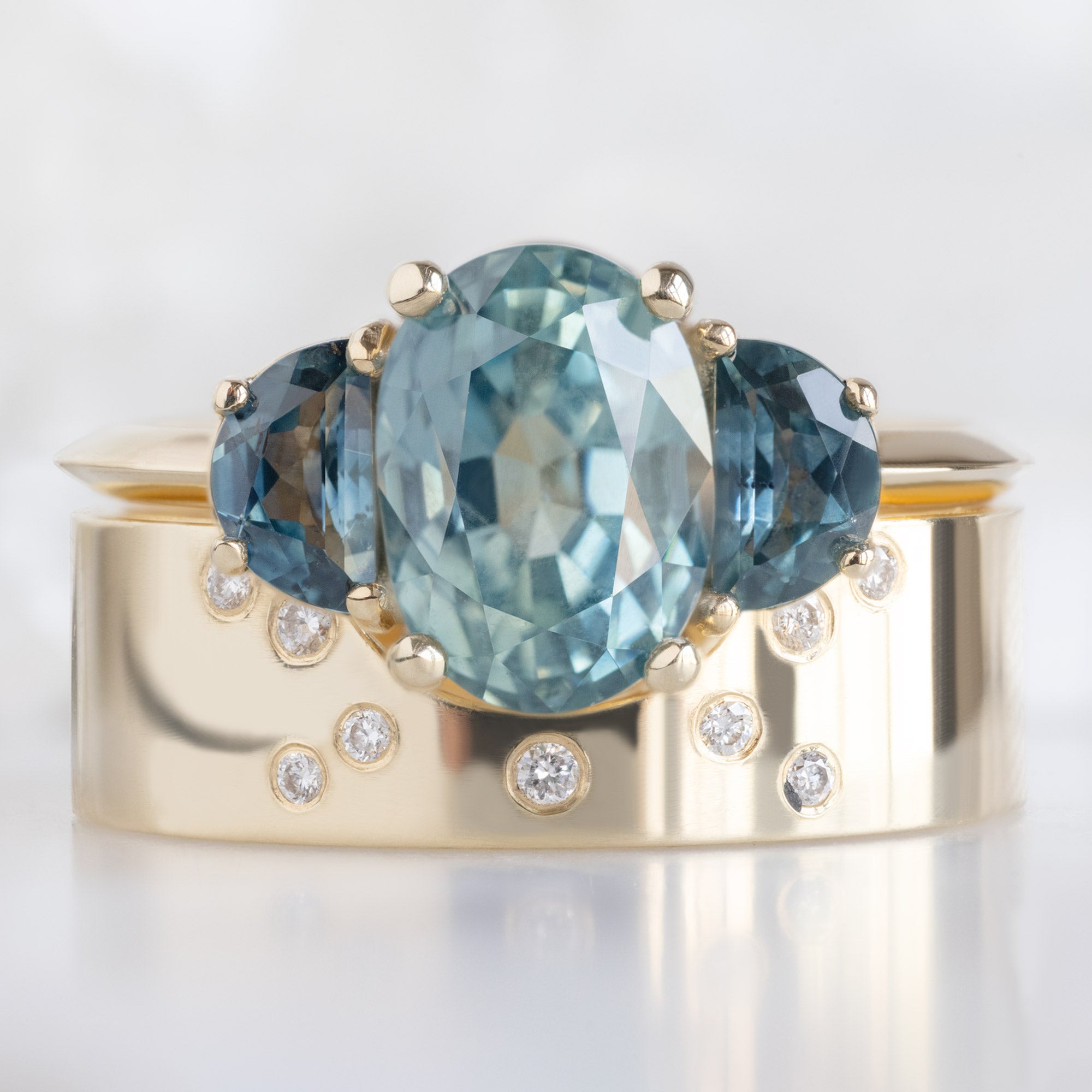 The 3 Stone Ring with a 2.42ct Oval Sapphire in 14K Yellow Gold Stacked with the Constellation Arc Stacking Band