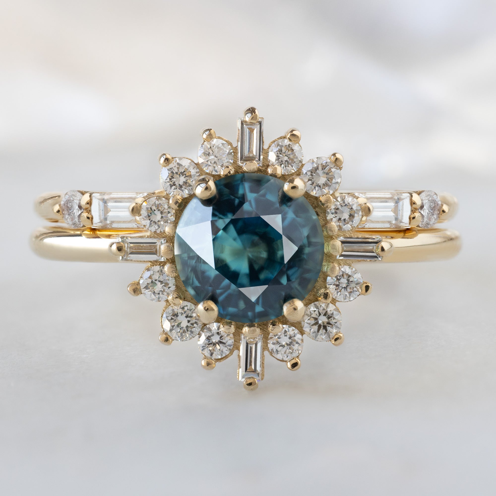 The Compass Ring with a 1.19ct Round Blue Sapphire in 14K Yellow Gold Stacked with the Luxe Open Cuff White Diamond Baguette Stacking Band