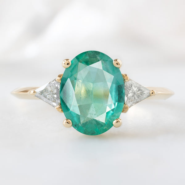 The Jade Ring with a 1.27ct Oval Emerald in 14K Yellow Gold on White Marble Surface