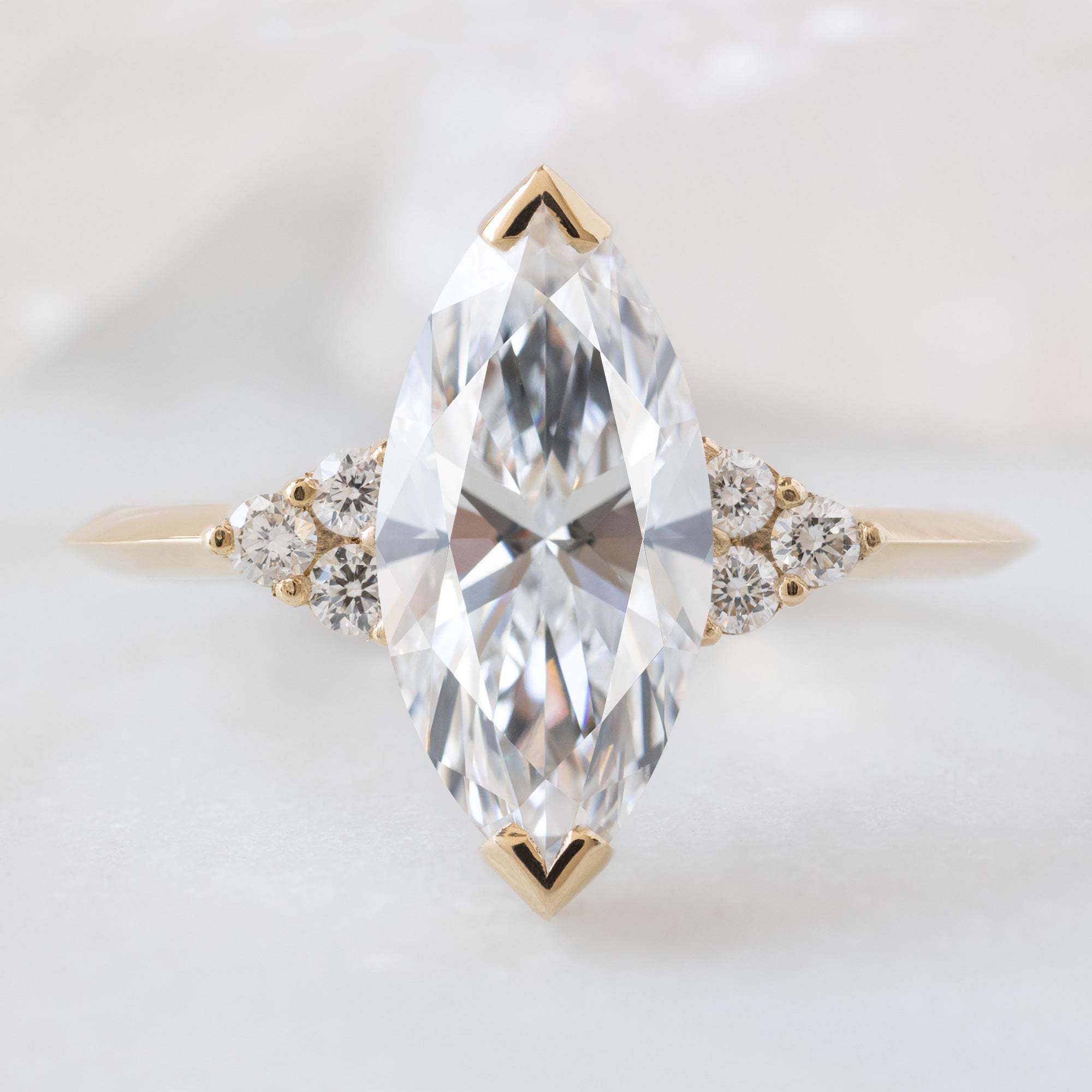 The Ivy Ring with a 1.64ct Marquise Lab Grown White Diamond in 14K Yellow Gold on White Marble Tile