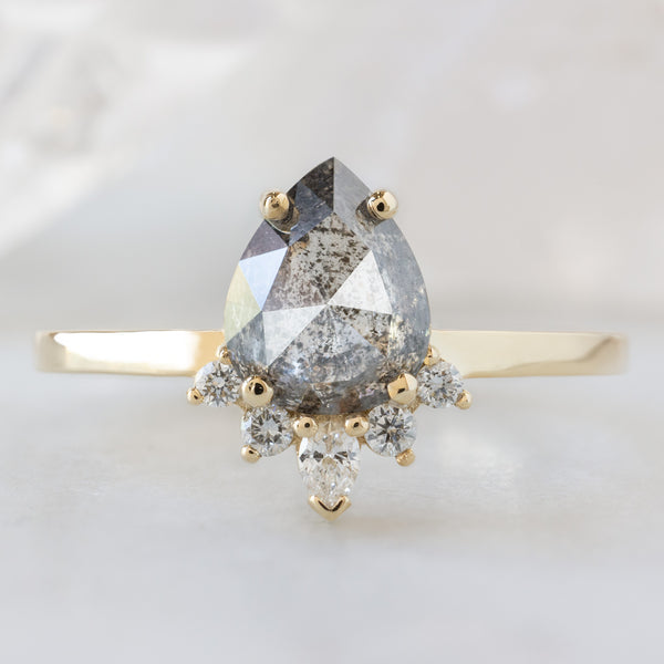 The Aster Ring with a 1.35ct Pear Salt and Pepper Diamond in 14K Yellow Gold on White Marble Surface