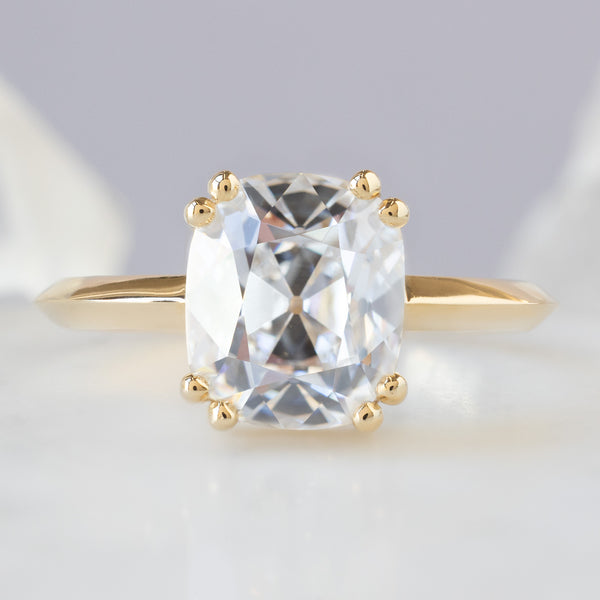 The Bryn Ring with a 2.32ct Old Mine Cut White Diamond in 14K Yellow Gold on Pale Blue Background