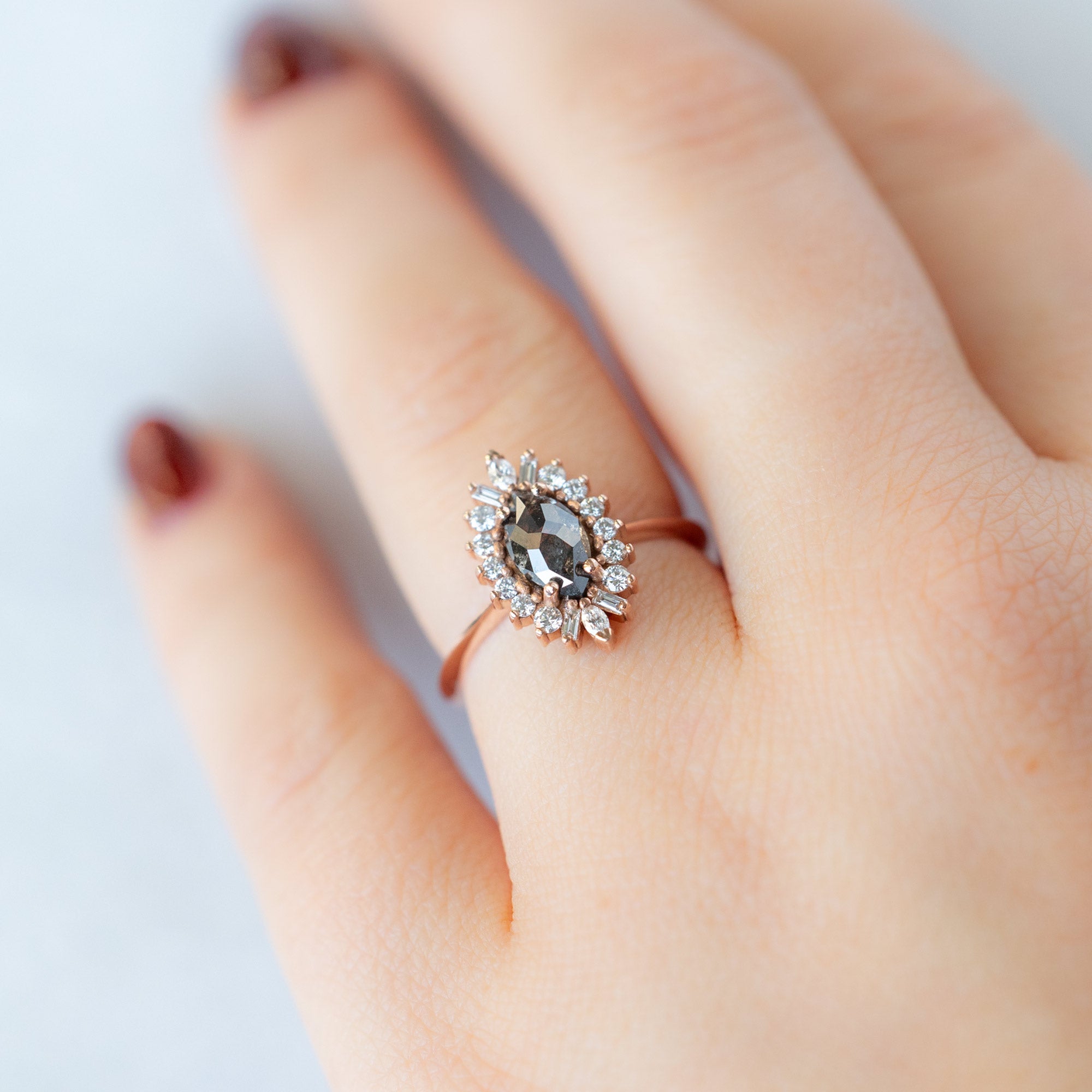 The Camellia Ring with a 0.94ct Marquise Cut Black Diamond in 14K Rose Gold on Model's left hand ring finger.