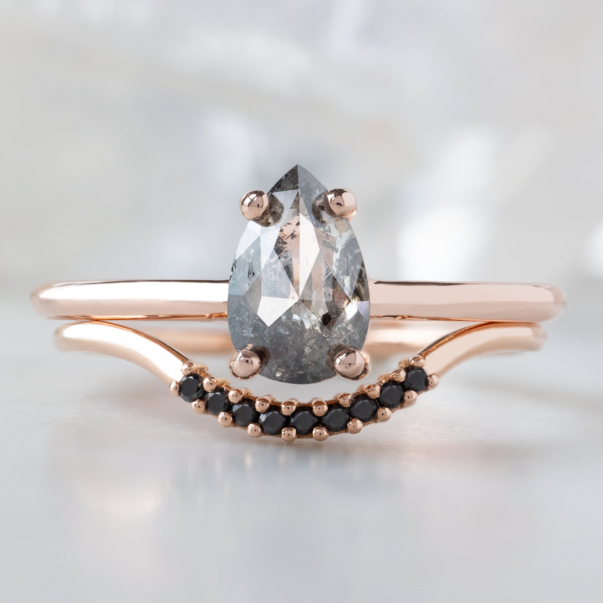 The Bryn Ring with a 0.90ct Pear Salt and Pepper Diamond in 14K Rose Gold Stacked with the Black Diamond Pavé Arc Stacking Band