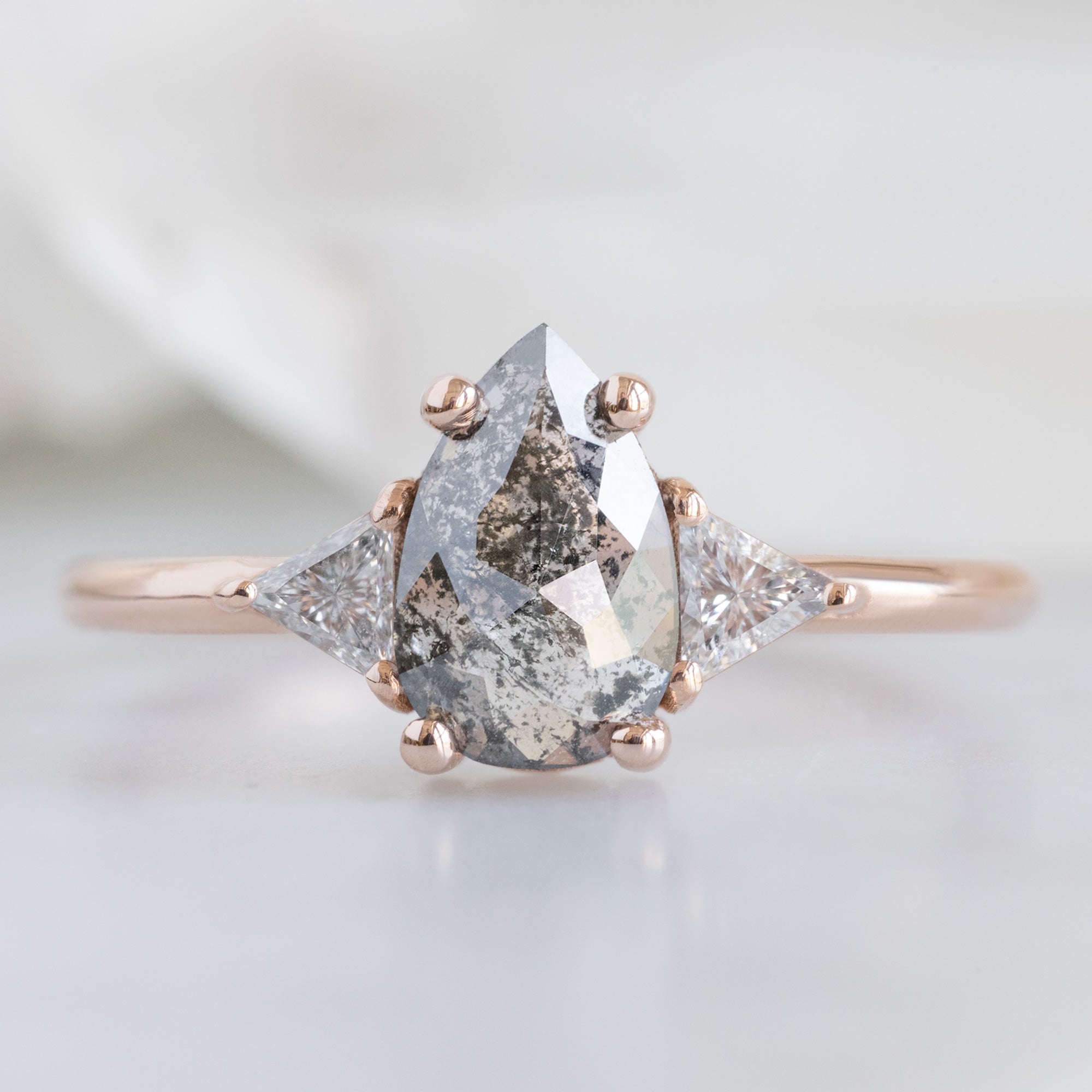The Jade Ring with a 0.83ct Pear Salt and Pepper Diamond in 14K Rose Gold on White Marble