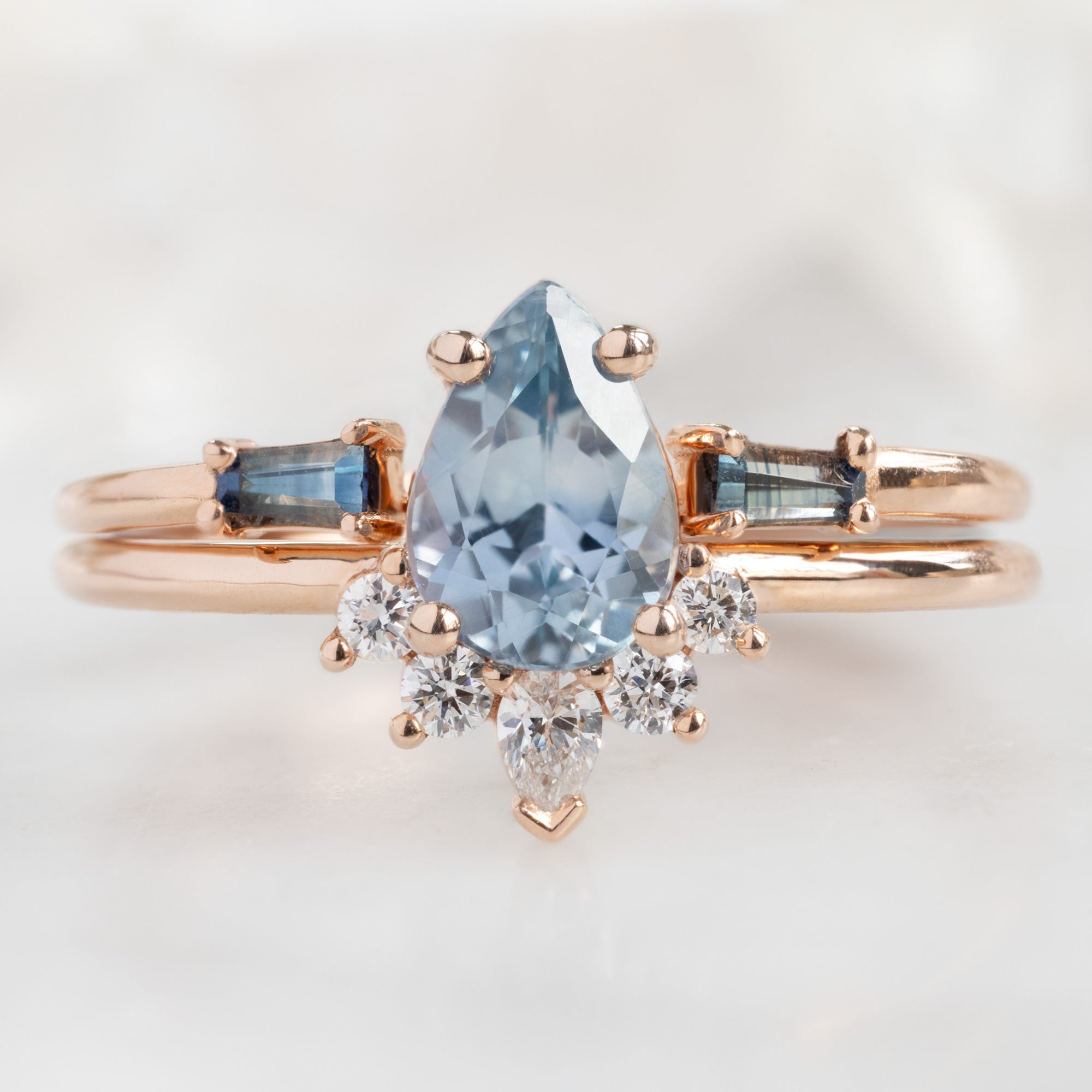 The Aster Ring with a Pear Blue Sapphire in 14K Rose Gold stacked with the Open Cuff Sapphire Baguette Stacking Band