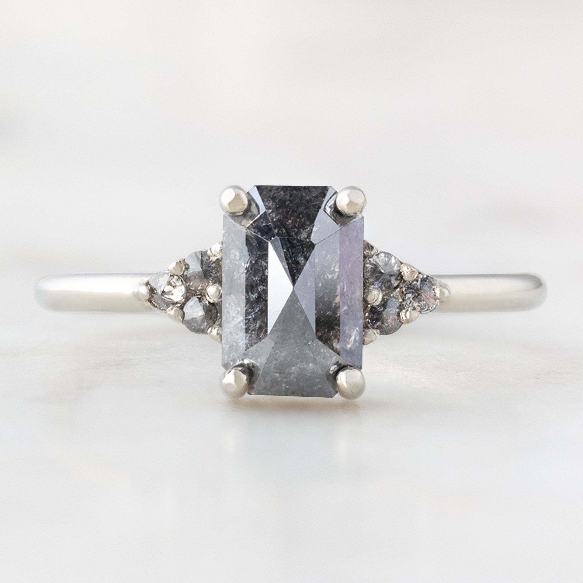 The Ivy Ring with a 1.35ct Emerald Cut Black Diamond in 14K White Gold on white background
