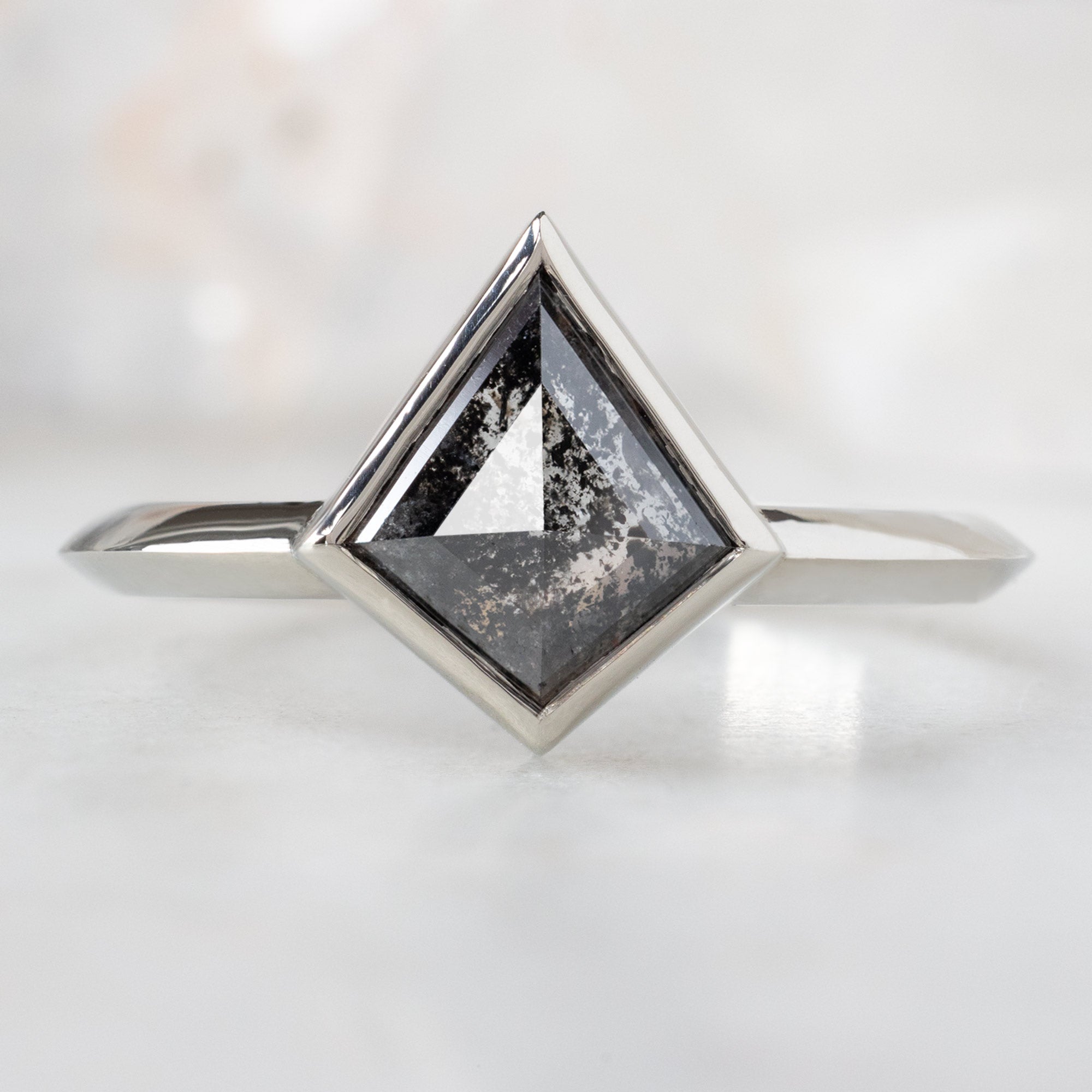 The Hazel Ring with a 1.37ct Black Kite Diamond in 14K White Gold on White Marble