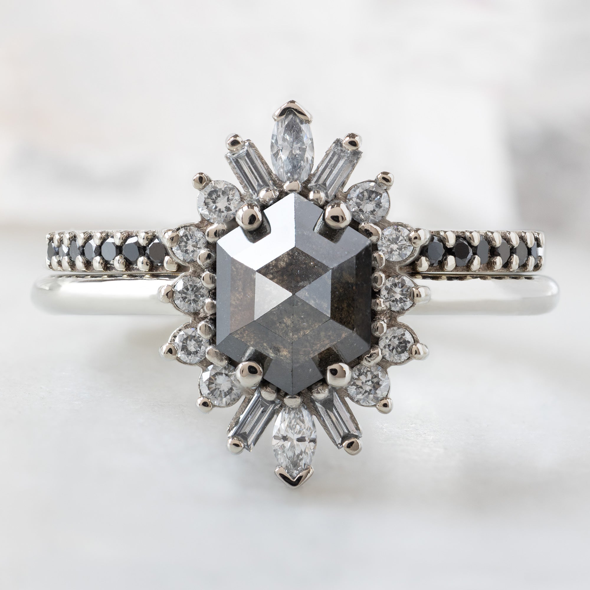 The Camellia Ring with a 0.94ct Hexagon Black Diamond in 14K White Gold Stacked with the Black Pavé Diamond Stacking Band on White Marble