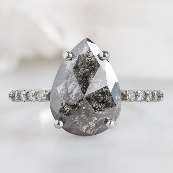 The Luxe Willow Ring with a 2.03ct Pear Black Diamond in 14K White Gold on White Marble Surface