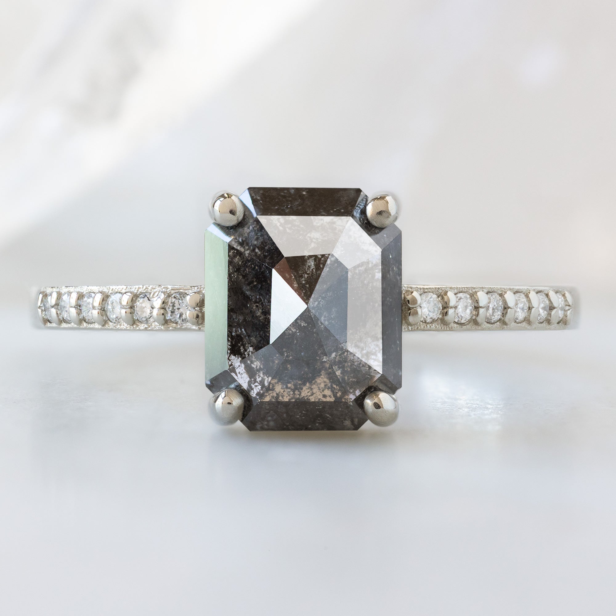 The Willow Ring with a 1.53ct Emerald Cut Black Diamond in 14K White Gold on White Marble Surface