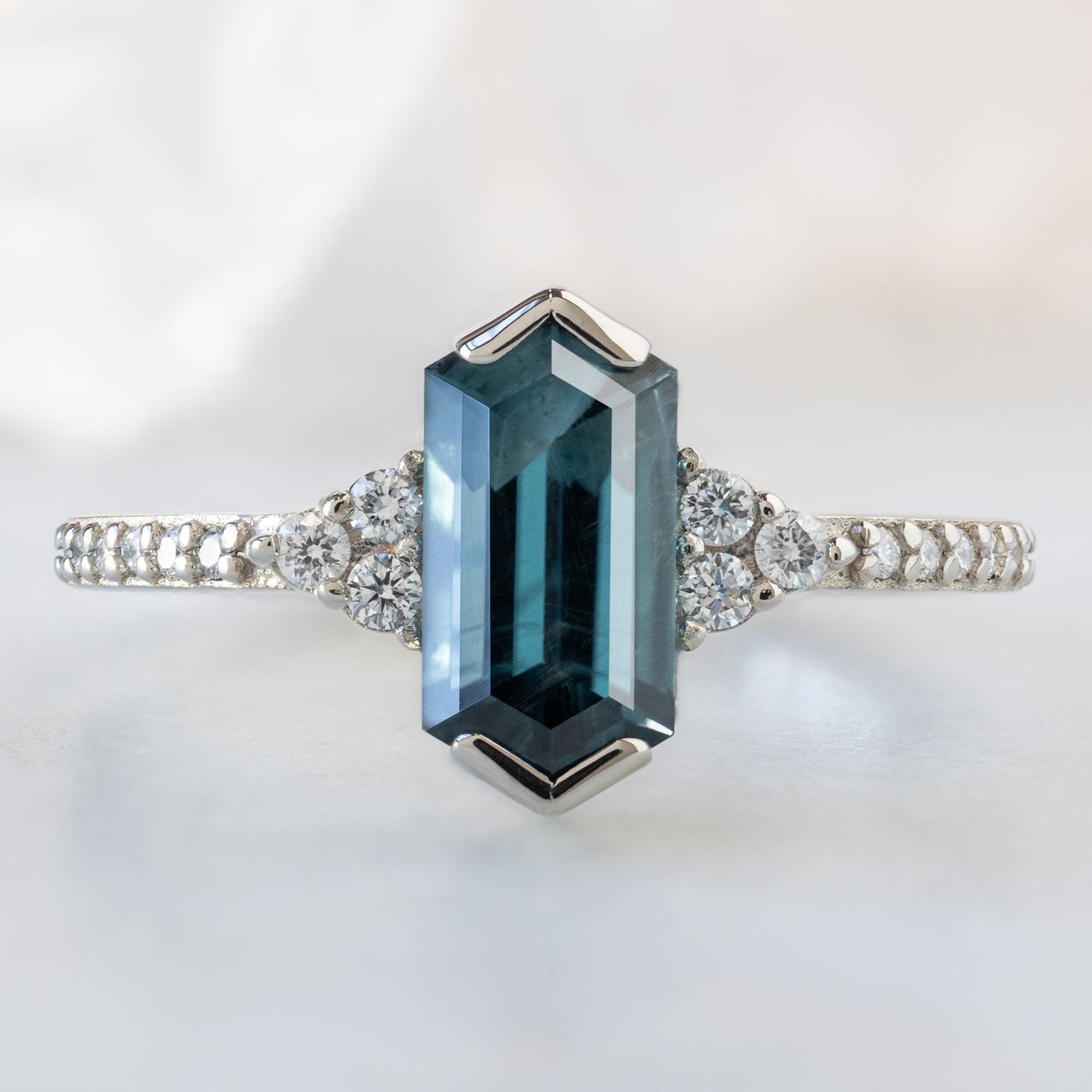 The Ivy Ring with a 1.22ct Hexagon Blue Spinel in 14K White Gold on White Marble Surface