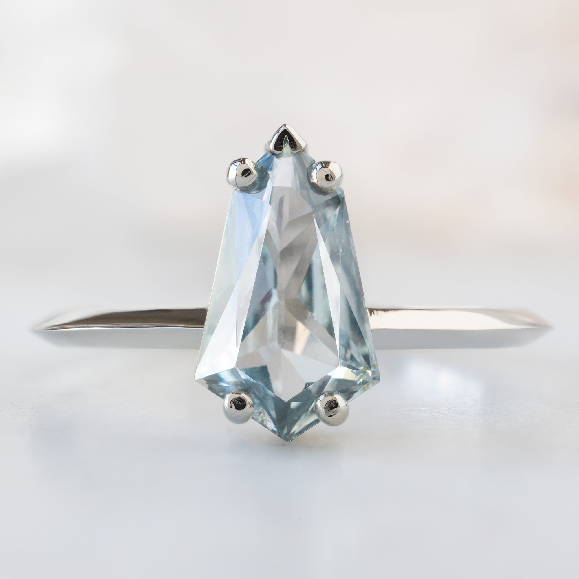 The Sage Ring with a 1.44ct Geometric Blue Sapphire in 14K White Gold on White Marble Surface