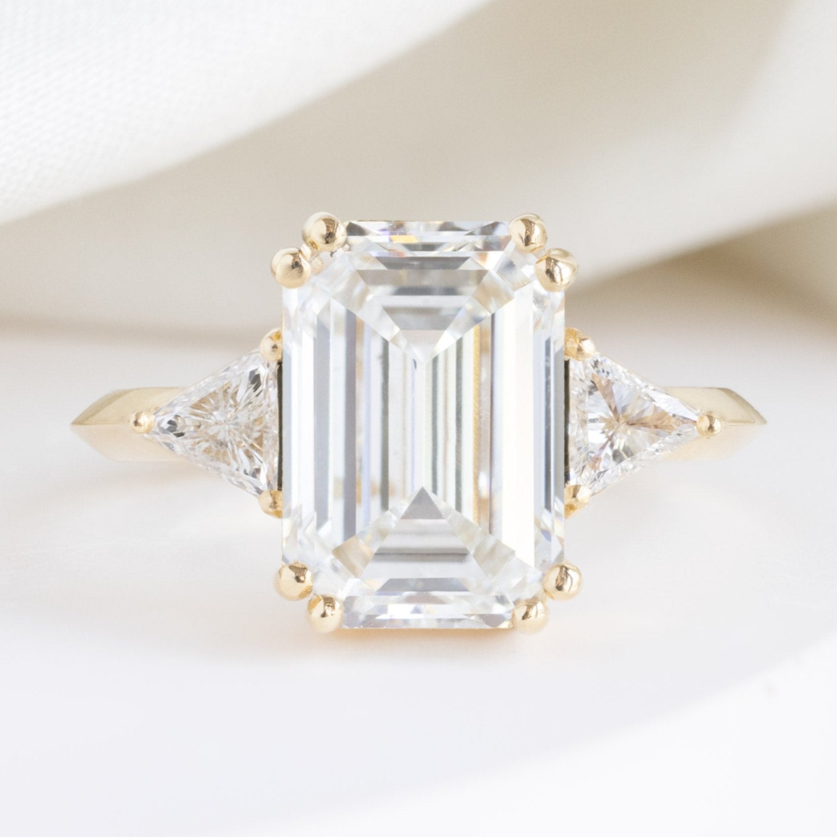 The Jade Luxe with a 3.33ct Lab Grown Emerald Cut Diamond in 18K Yellow Gold on White Marble