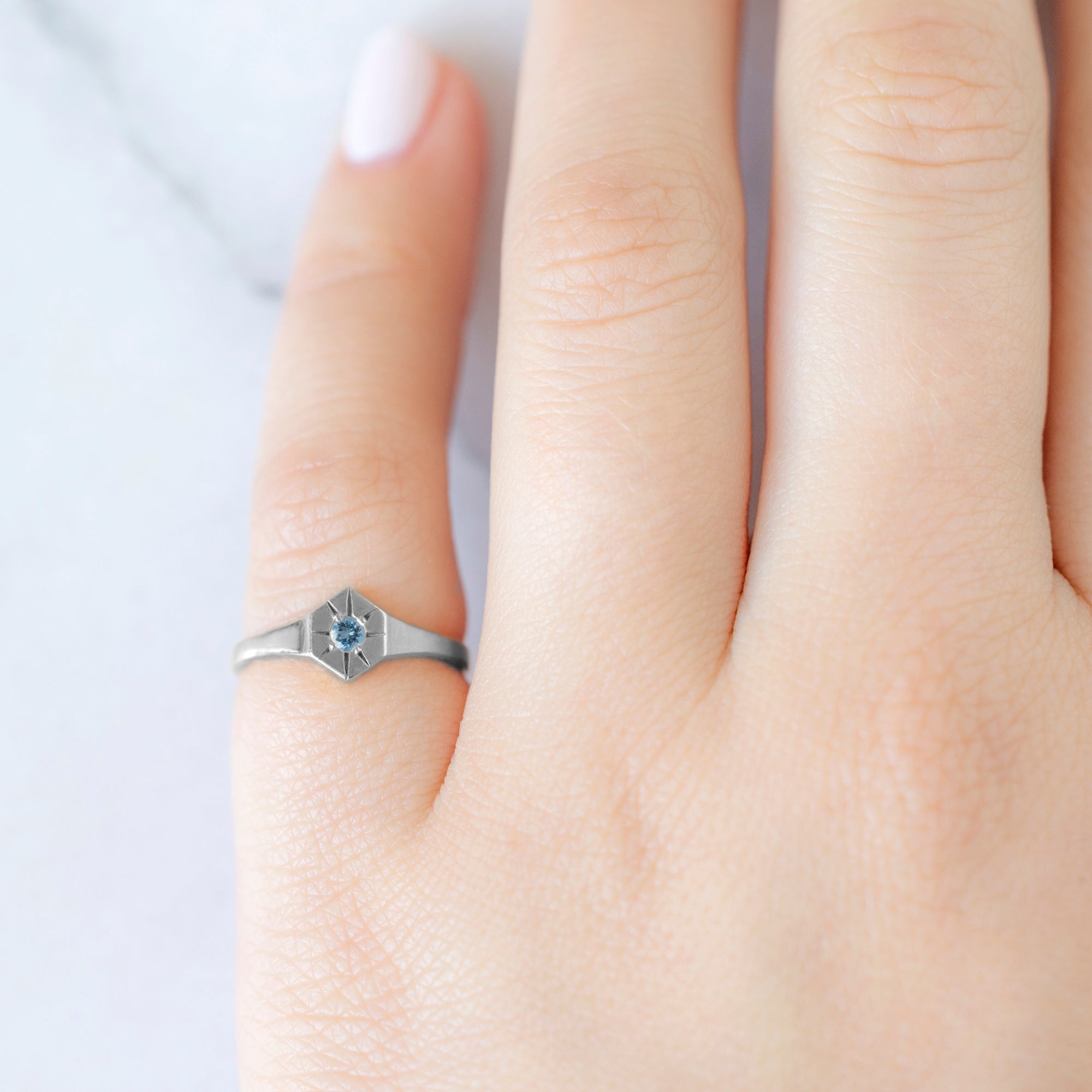 Custom Aquamarine Birthstone Signet Ring | 10K White Gold displayed on model's left hand pinky finger.