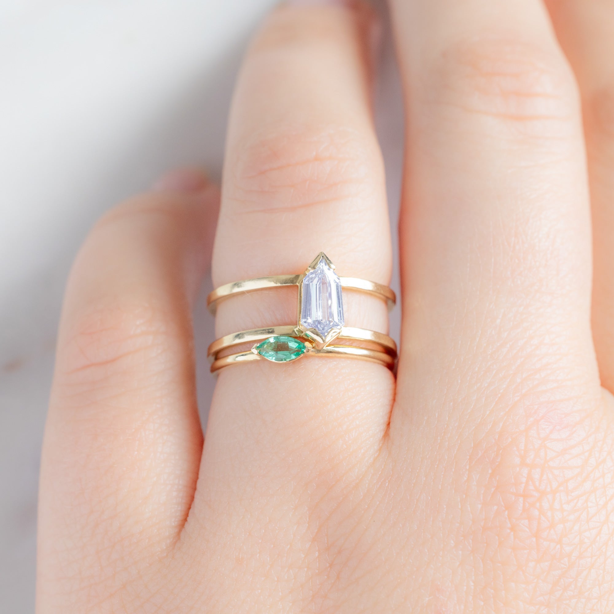 The Teensy Emerald Ring in 14k Yellow Gold stacked with double band white diamond engagement ring on model