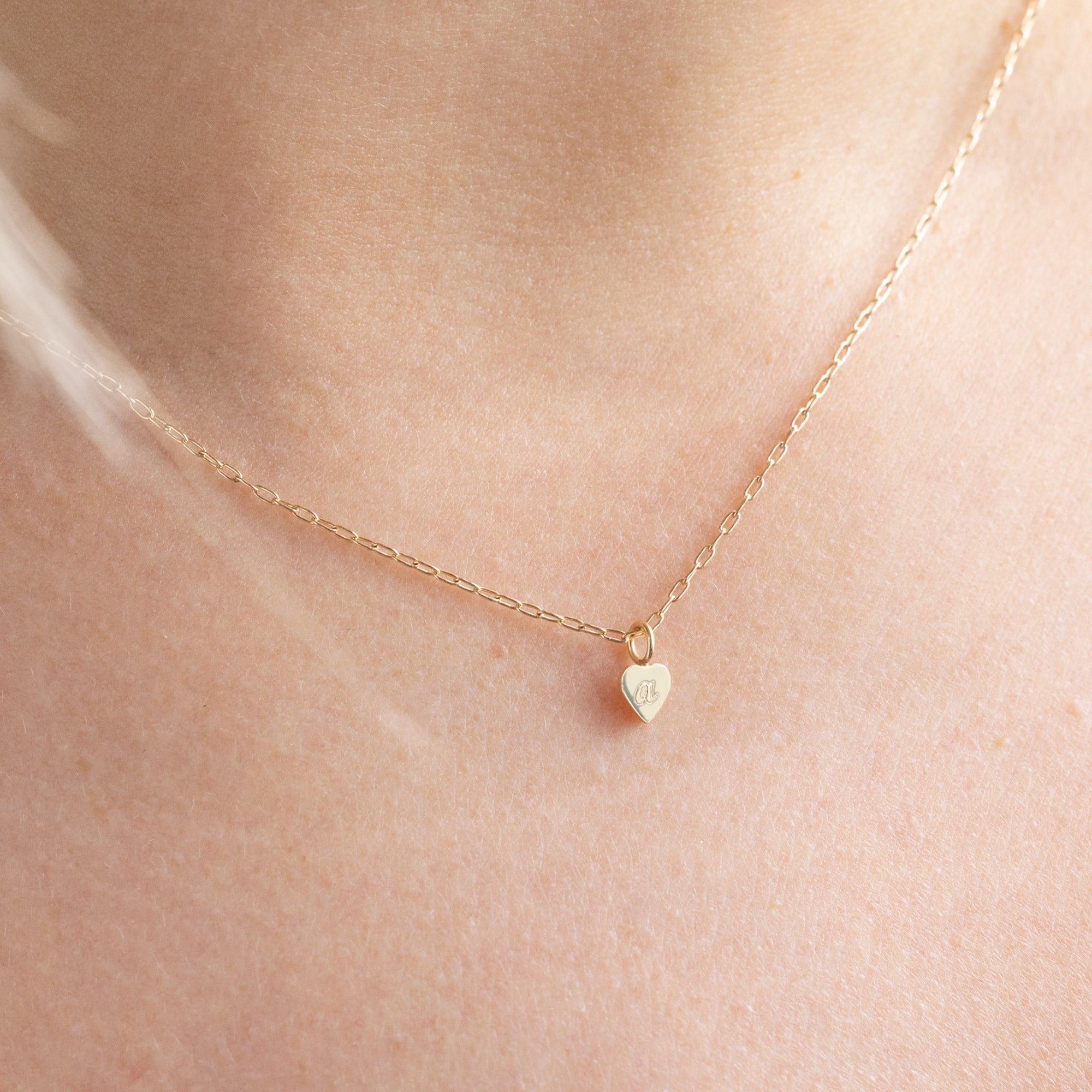 The Heart Pendant Necklace with an engraved 'A' in Yellow Gold on Model